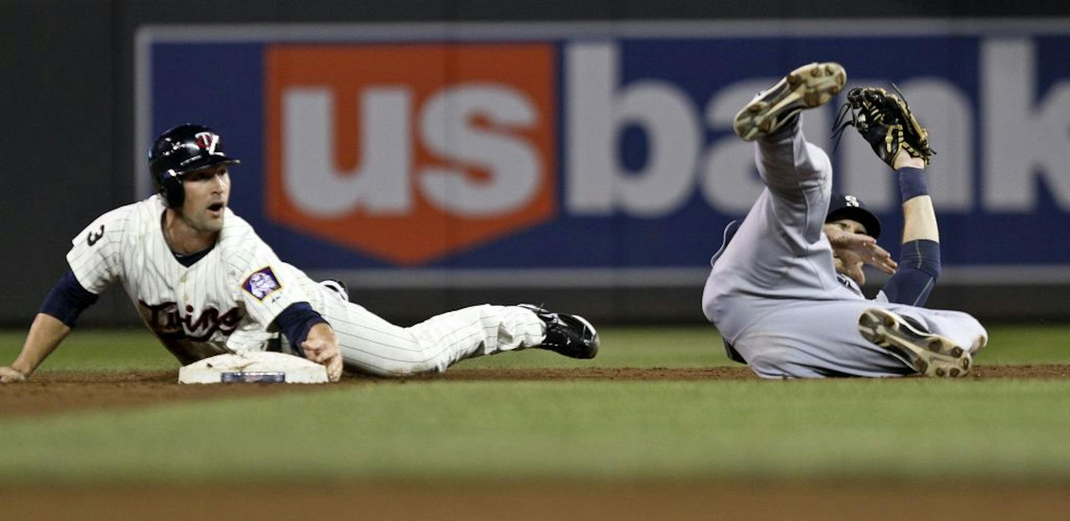Brian Dinkelman slid into second base after Seattle's Dustin Ackley missed the tag in the second inning.