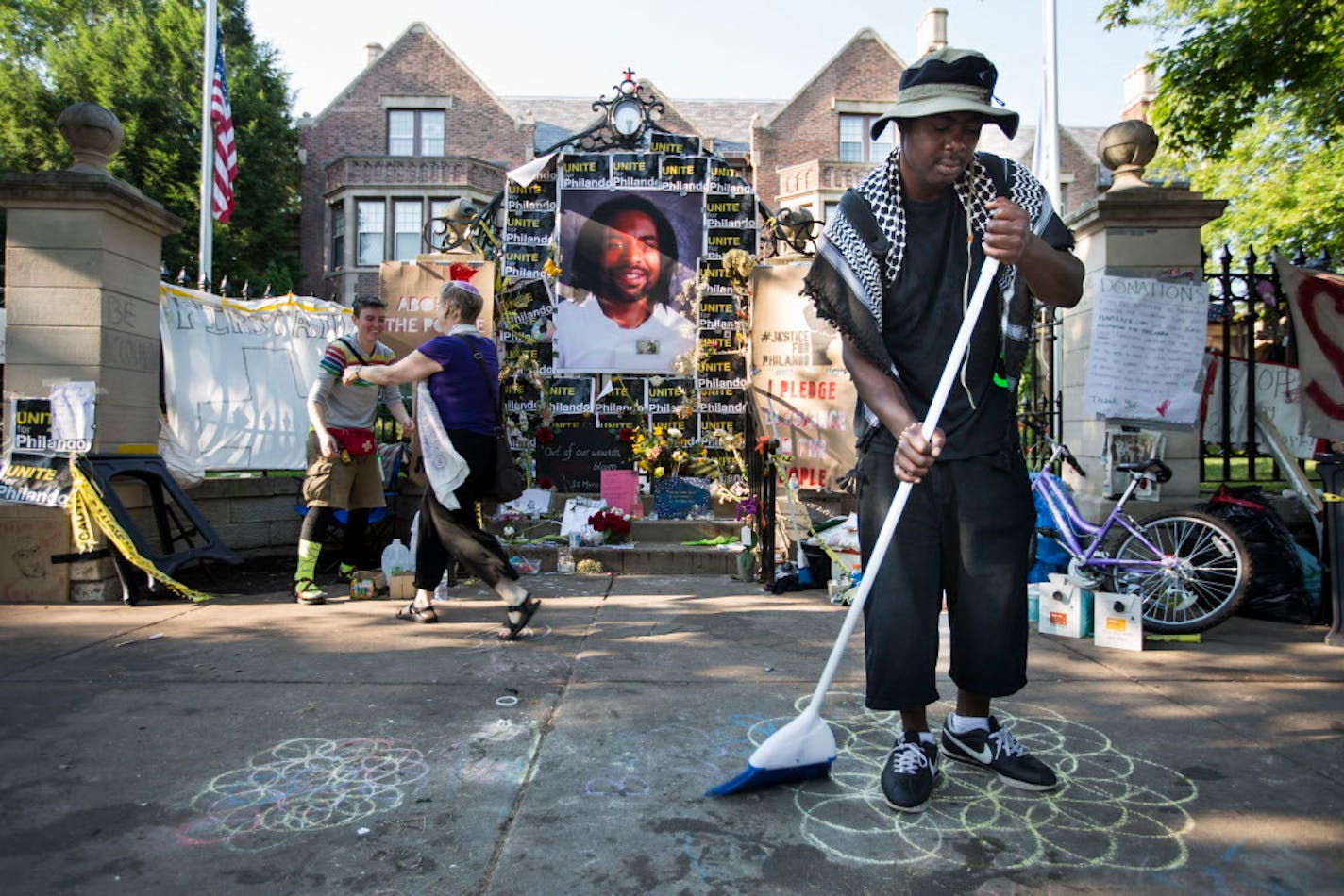 Henry Habu of Minneapolis sweeps the sidewalk outside the Governor's residence in St. Paul. ] (Leila Navidi/Star Tribune) leila.navidi@startribune.com BACKGROUND INFORMATION: Monday, July 18, 2016 at the Governor's residence in St. Paul. Protesters of the shooting death of Philando Castile stood their ground on the sidewalk outside the Governor's residence after the St. Paul Police opened Summit Avenue back up to traffic early Monday morning.