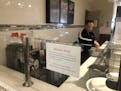 Tan Do finishes cleaning up Tuesday afternoon at his downtown Minneapolis restaurant, Skyway Wok, after deciding to close for most of the rest of the 
