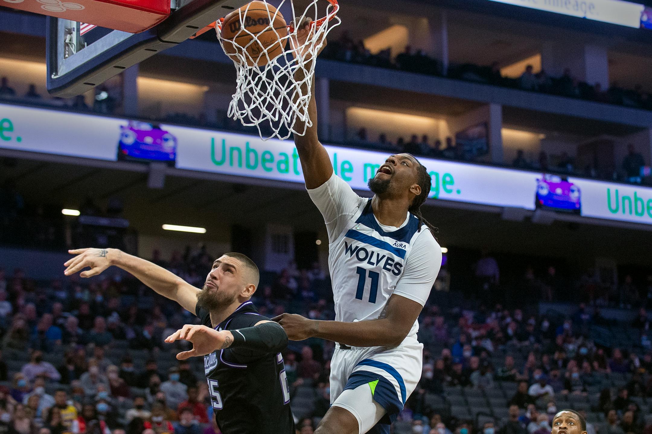 Minnesota Timberwolves center Naz Reid (11) dunks over Sacramento Kings center Alex Len during the first quarter of an NBA basketball game in Sacramento, Calif., Tuesday, Feb. 8, 2022. (AP Photo/Randall Benton)