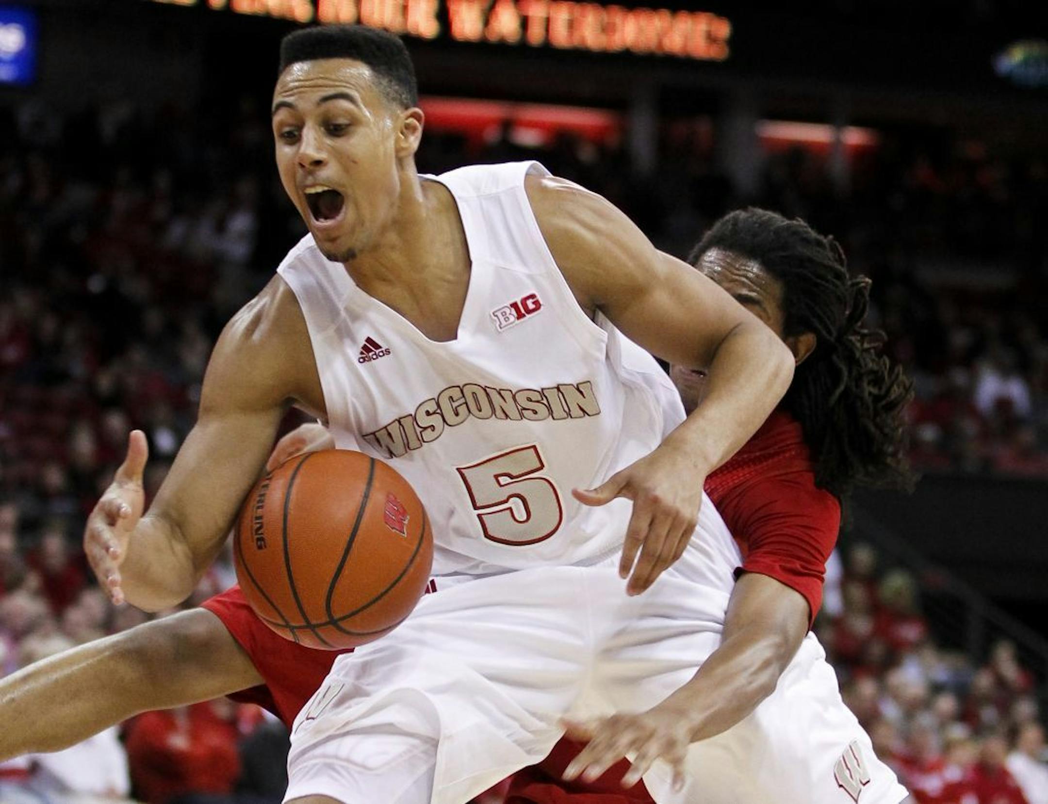 Nebraska's David Rivers reaches from behind Wisconsin's Ryan Evans for the ball during the second half of an NCAA college basketball game Tuesday, Feb. 26, 2013, in Madison, Wis. Wisconsin beat Nebraska 77-46.