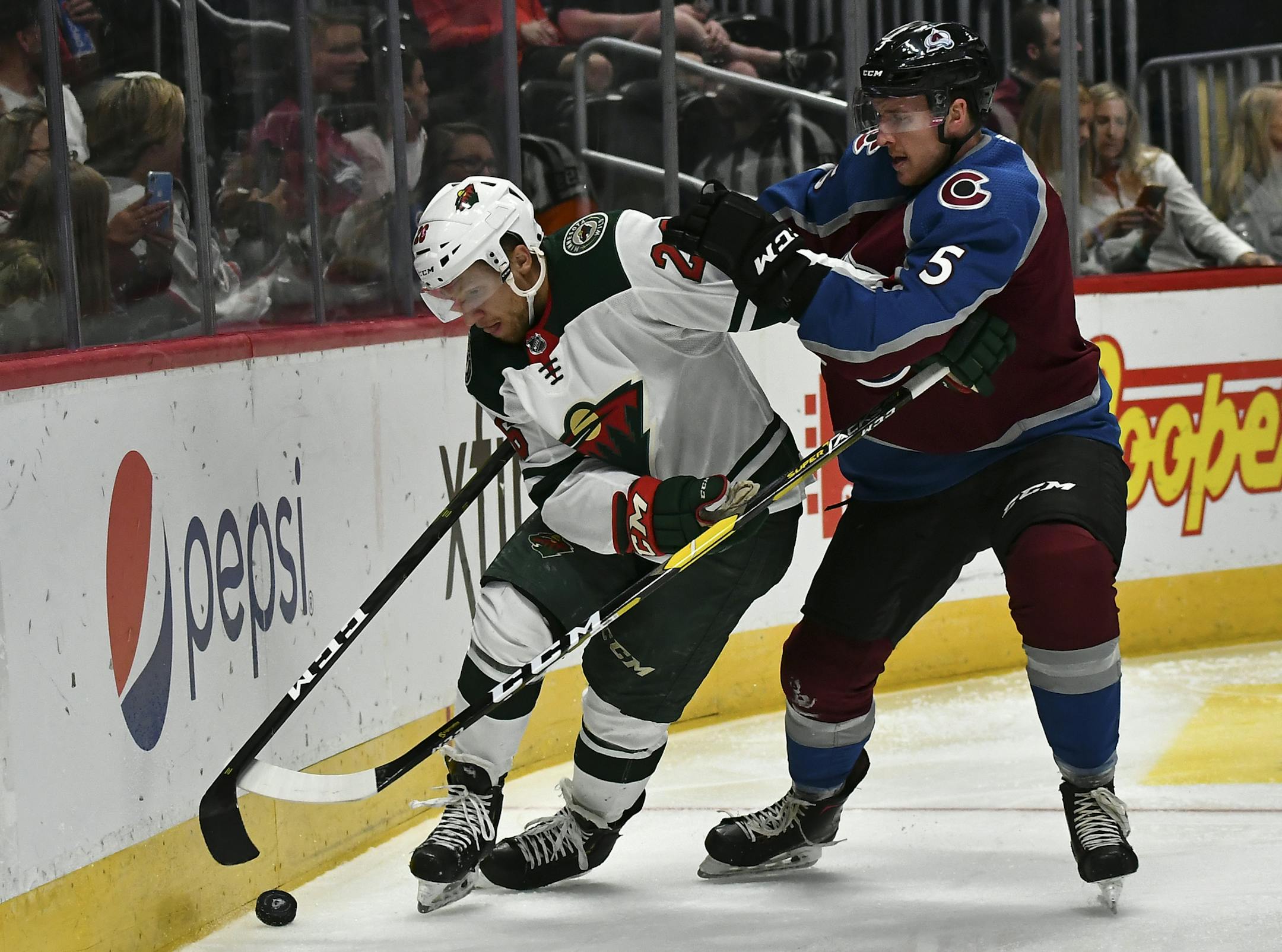 Minnesota Wild's Gerald Mayhew (26) battles for the puck along the boards with Colorado Avalanche defenseman Dan Renouf (5) during the second period in an NHL preseason hockey game Sunday, Sept. 22, 2019 in Denver (AP Photo/John Leyba)