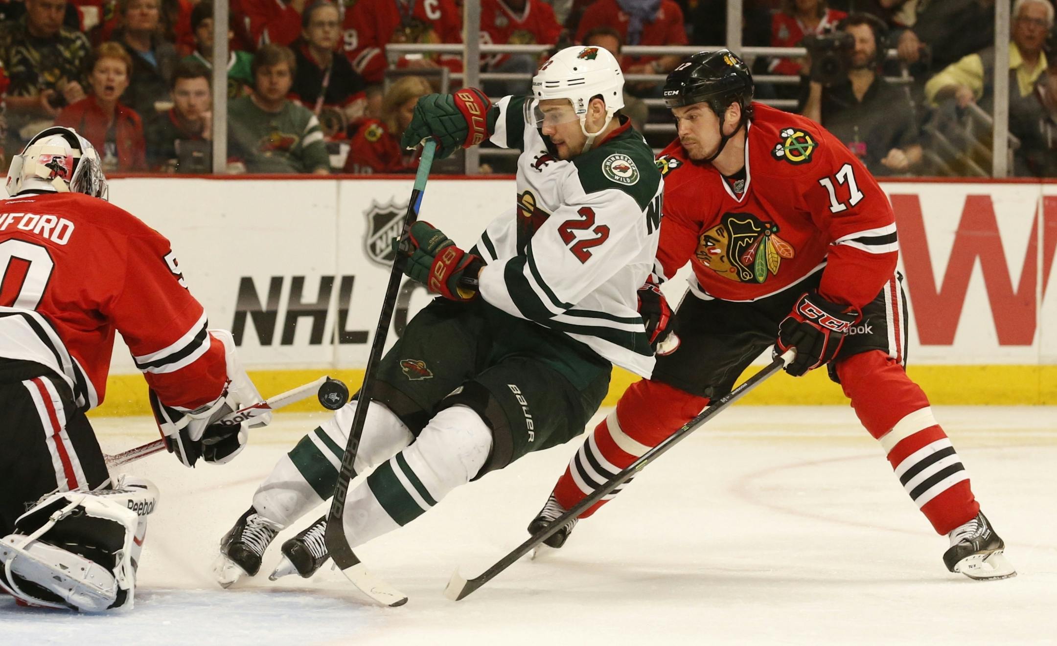 Minnesota Wild right wing Nino Niederreiter (22) works the from of the net as Chicago Blackhawks defenseman Sheldon Brookbank (17) follows during the third period of their game Sunday at the United Center.