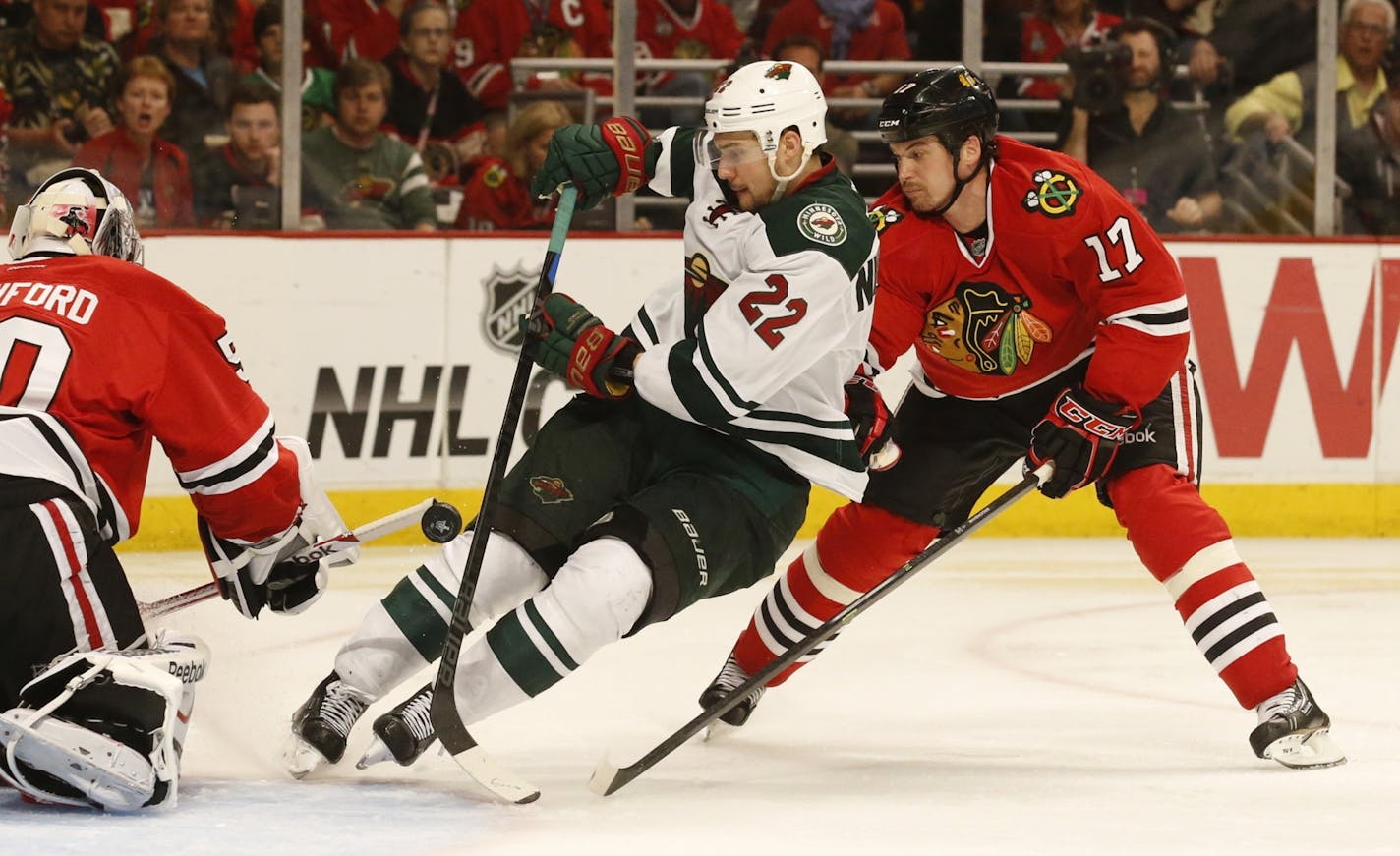 Minnesota Wild right wing Nino Niederreiter (22) works the from of the net as Chicago Blackhawks defenseman Sheldon Brookbank (17) follows during the third period of their game Sunday at the United Center.