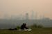 Smoke from wildfires blankets the city as a couple has a picnic in Edmonton, Alberta, Saturday, May 11, 2024.