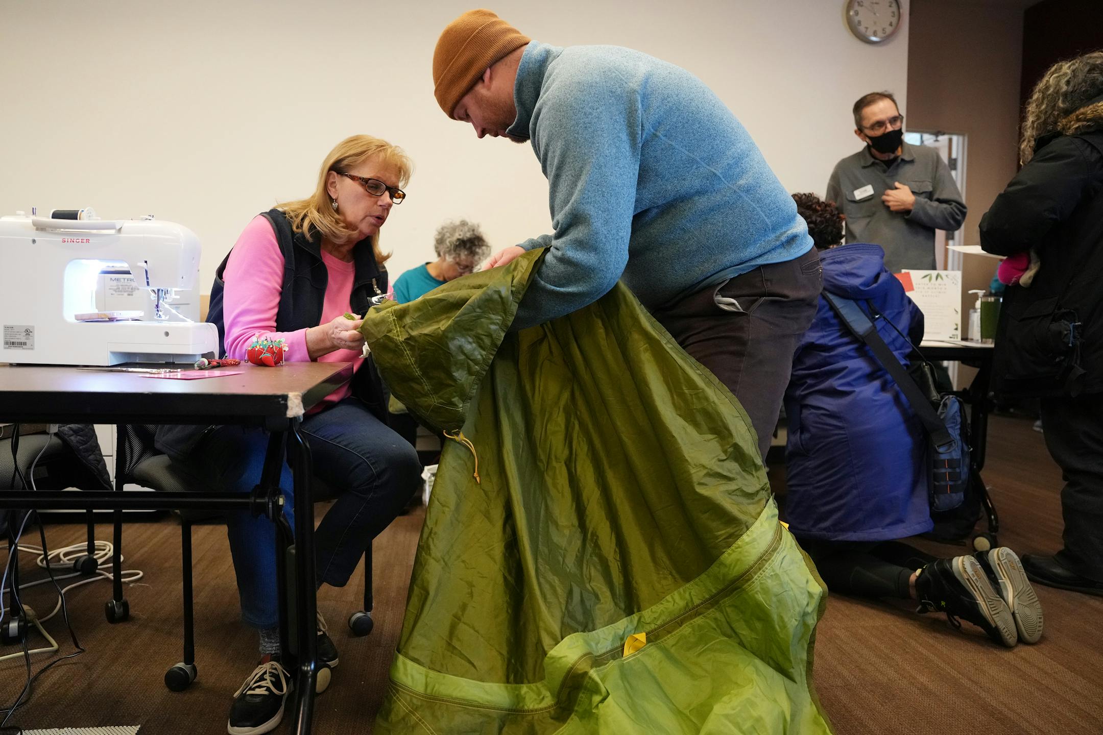Mike Lindsay looked over repairs needed on his North Face tent with Jan Smith during a Ramsey County Fix-It Clinic Saturday, Nov. 19, 2022, at the Ramsey County Library in Maplewood.