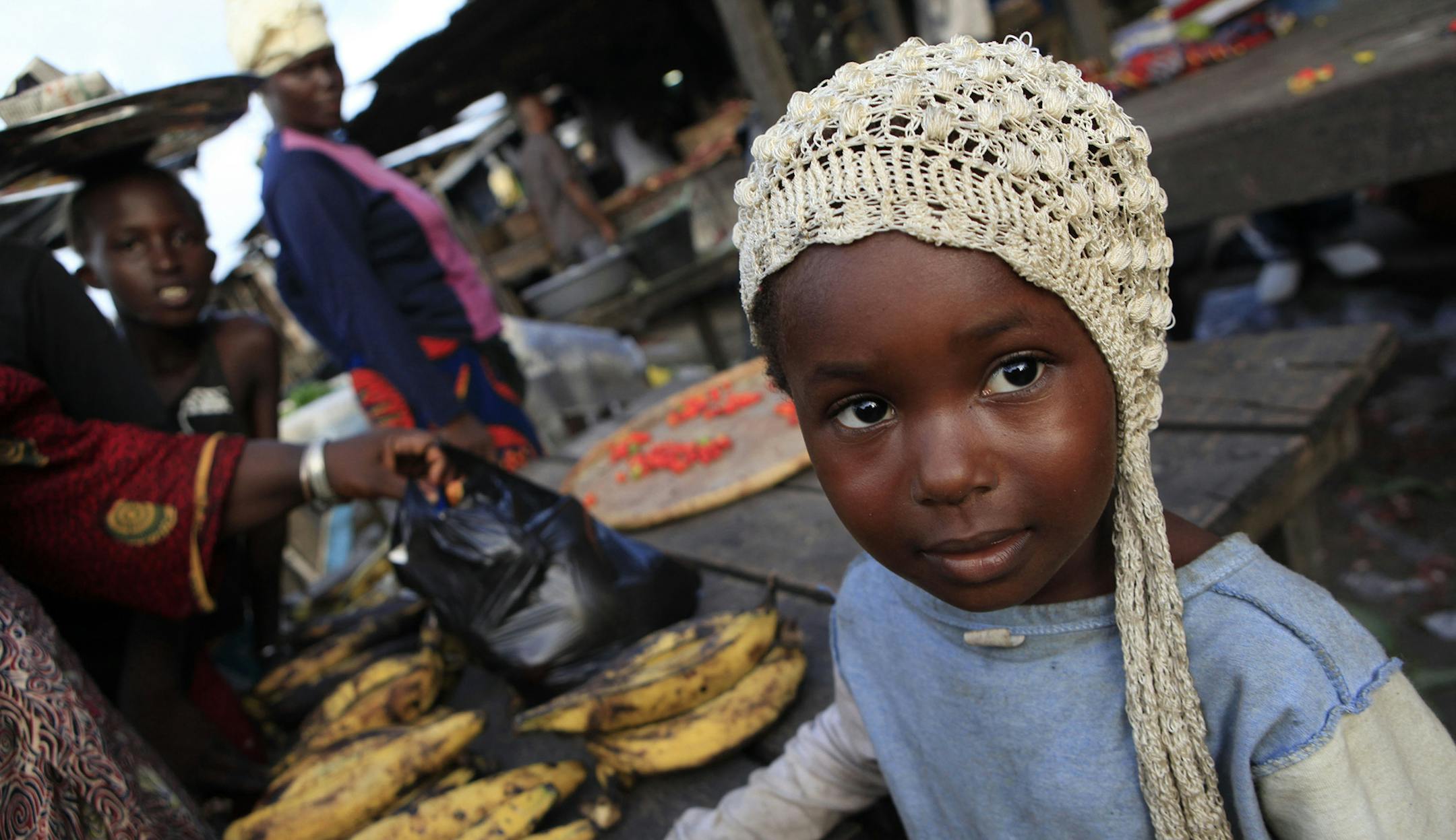Fanta Bamba, 3, leans on her mother's fruit and vegetable stand, in a market in the Abobo neighborhood of Abidjan, Ivory Coast, Sunday, April 17, 2011. Ibrahim Coulibaly, the commander who began the battle to wrest Ivory Coast's commercial capital from soldiers who fired rockets and mortars on a poor neighborhood, said Sunday that a lack of military coordination cost too many lives, infrastructure damage and unnecessary looting. (AP Photo/Rebecca Blackwell) ORG XMIT: RLB120