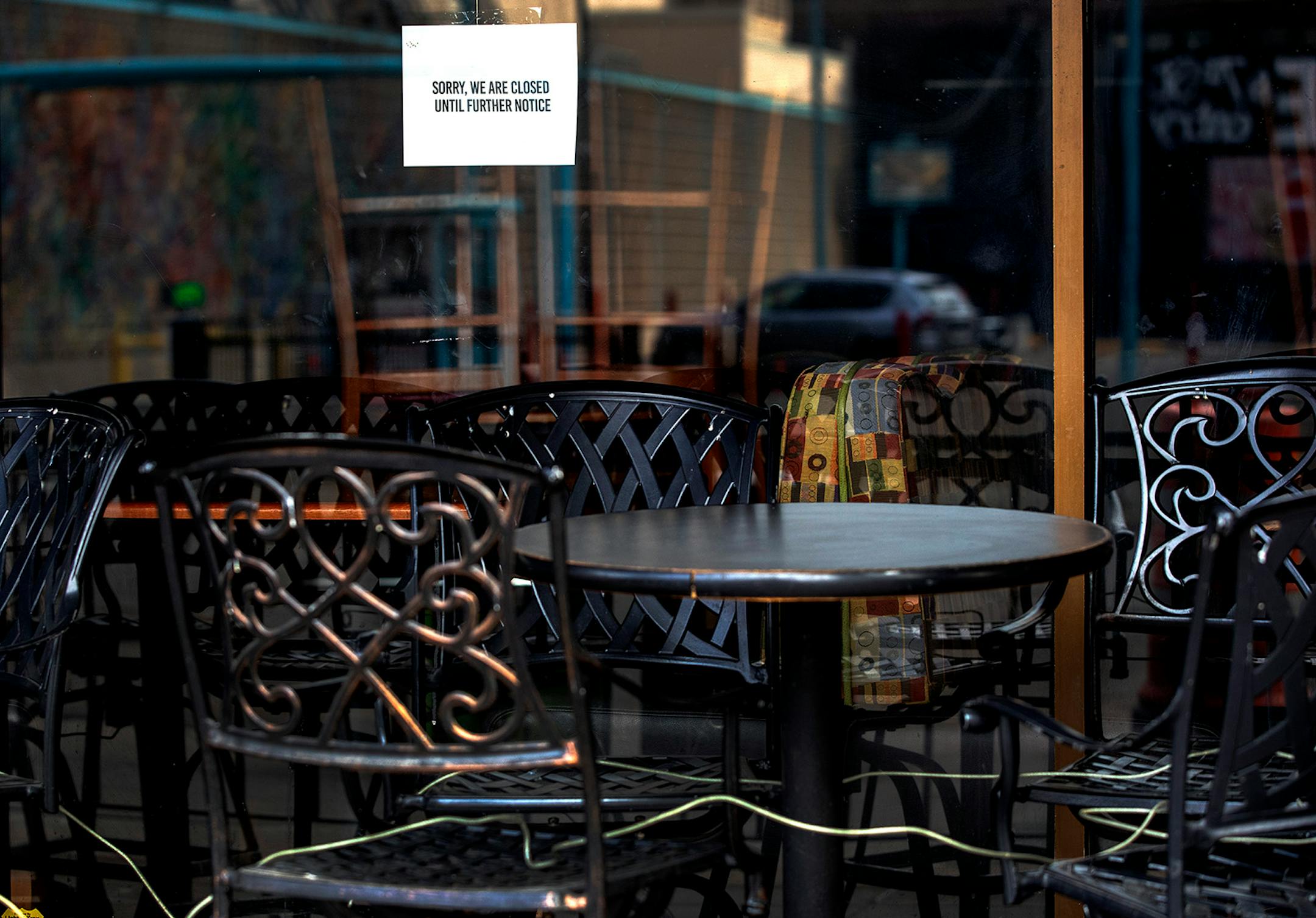 A closed sign and empty outdoor chairs at Maruso Street Food & Cocktails in Minneapolis.