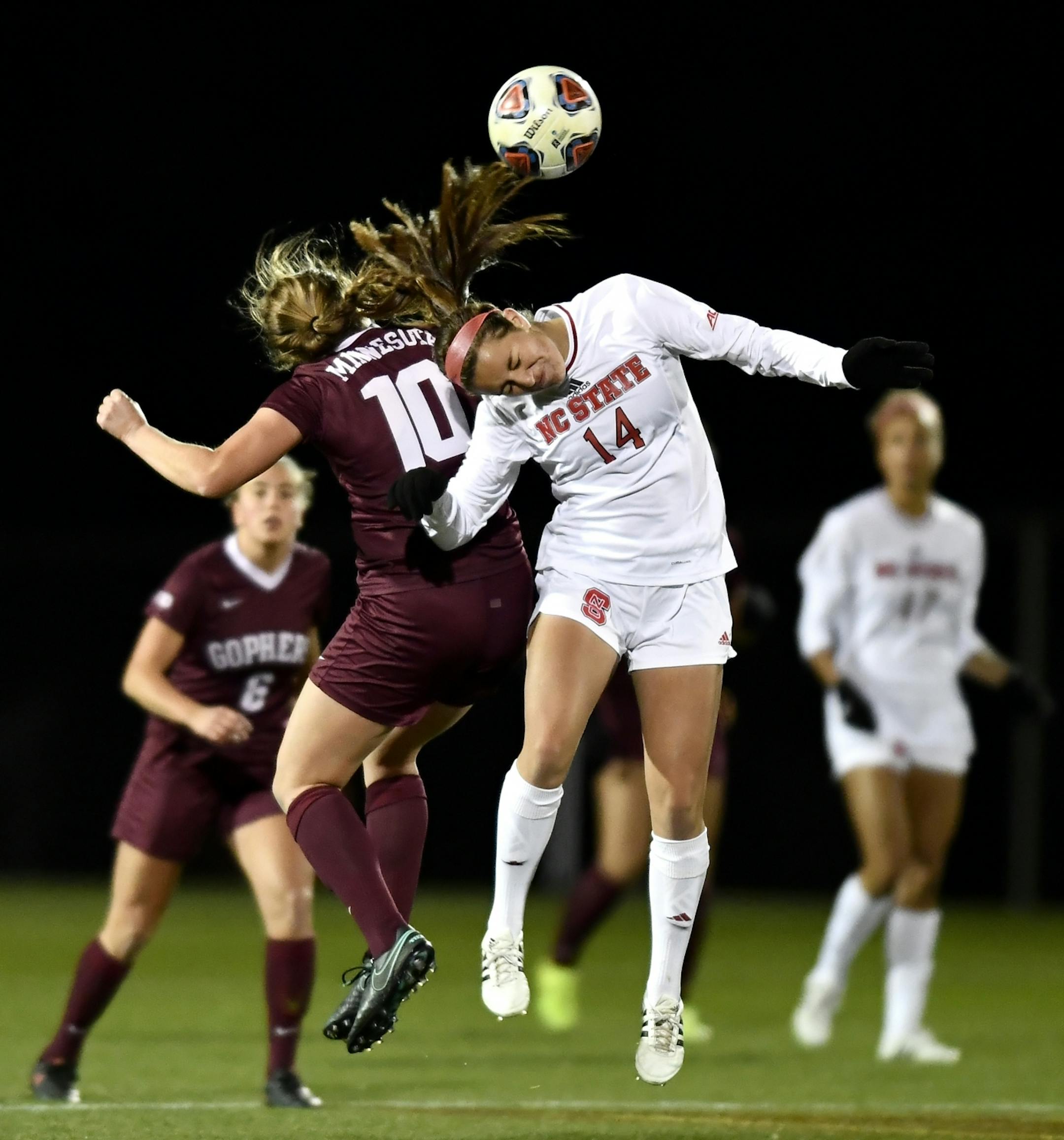 NC State midfielder Taylor Porter (14) and Minnesota midfielder Emily Heslin (10) jumped for a header in the first half Saturday night.