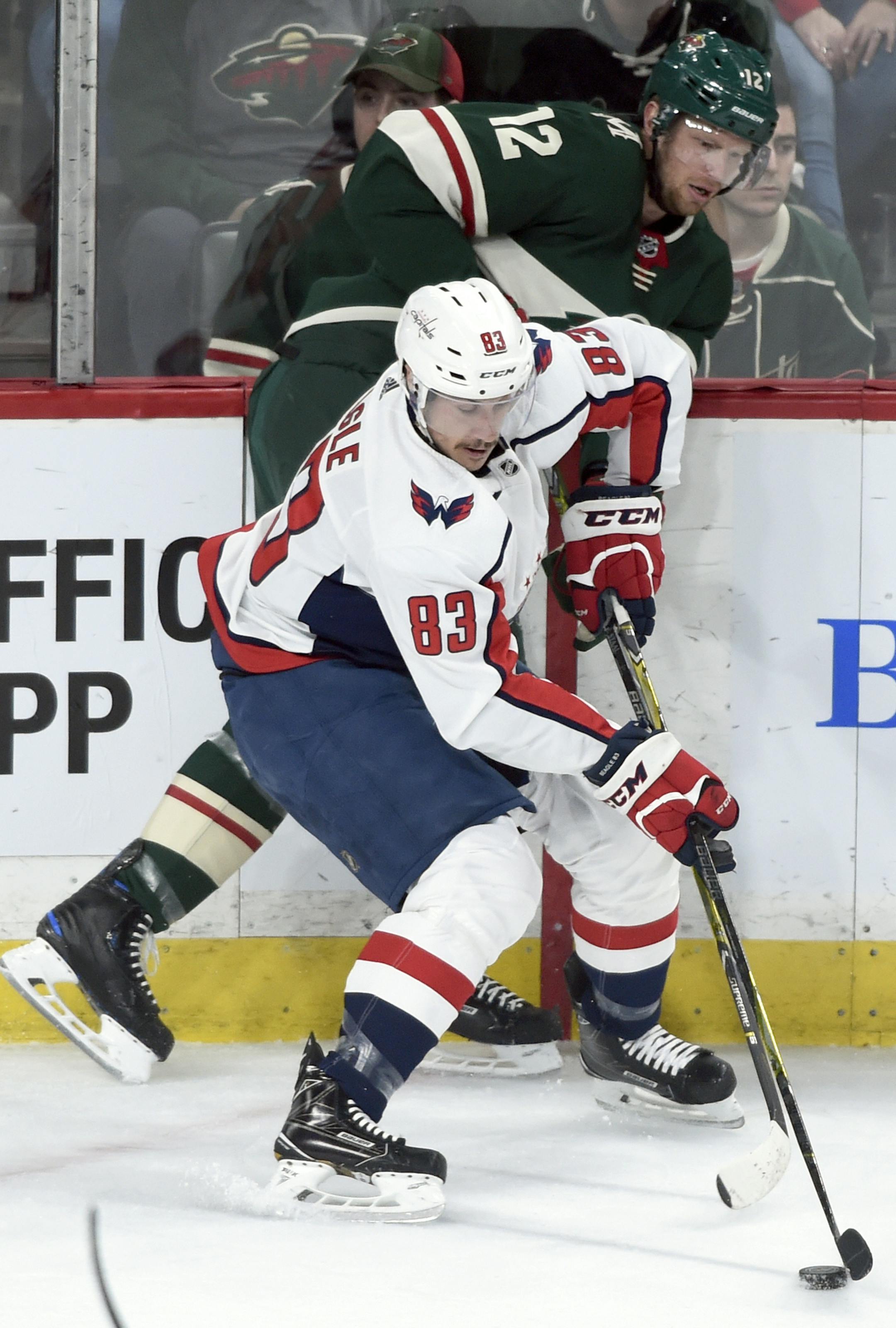 Washington Capitals' Jay Beagle (83) pins Minnesota Wild's Eric Staal (12) to the boards during the first period of an NHL hockey game Thursday, Feb. 15, 2018, in St. Paul, Minn. (AP Photo/Hannah Foslien)