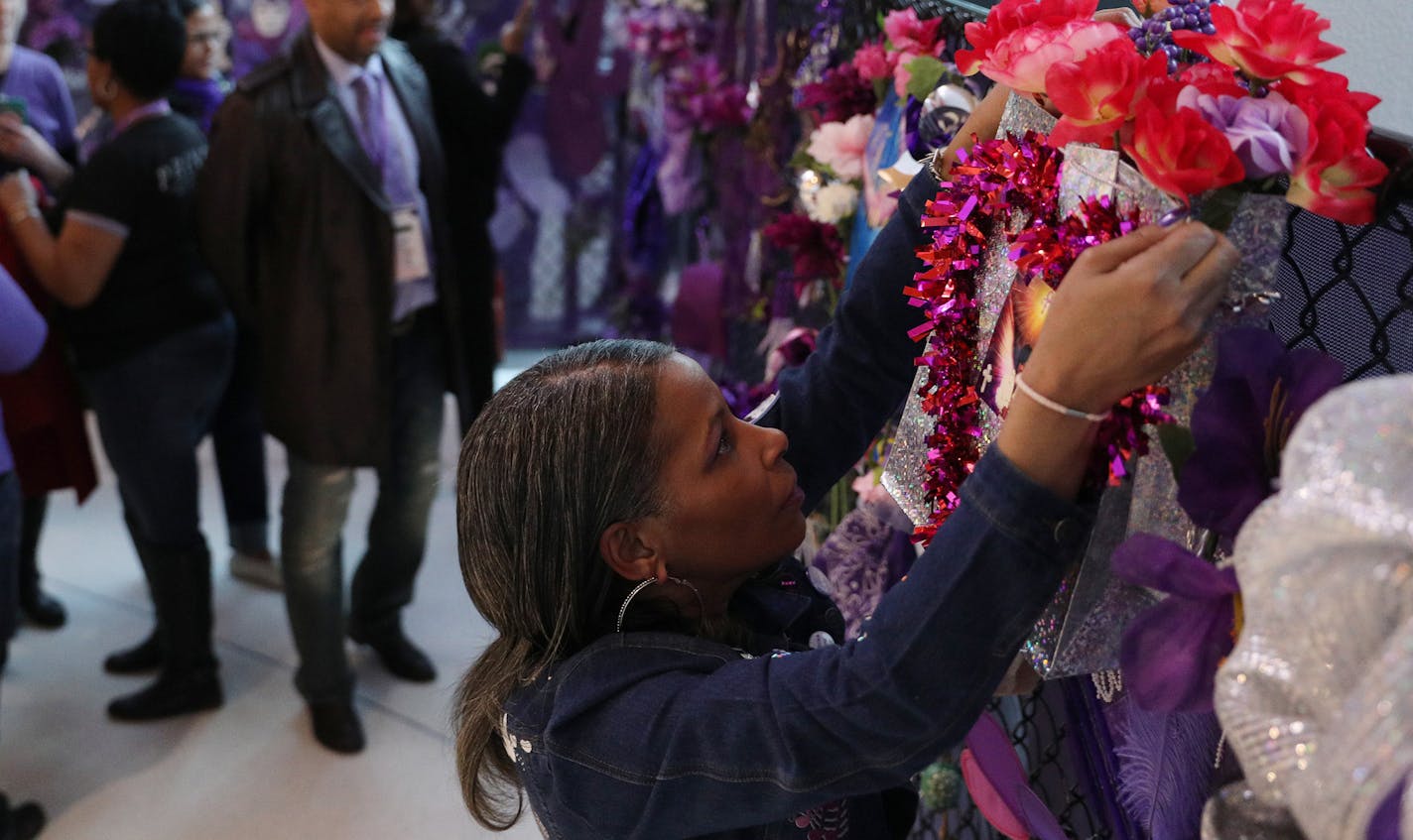 Prince fan Melissa Rassi of Detroit hung a bag of flowers at a section of the fence memorial constructed in the lobby of the Target Center prior to the start of Prince: Live on the Big Screen Friday. ] ANTHONY SOUFFLE &#xef; anthony.souffle@startribune.com Fans gathered to see Prince: Live on the Big Screen Friday, April 20, 2018 at the Target Center in Minneapolis.