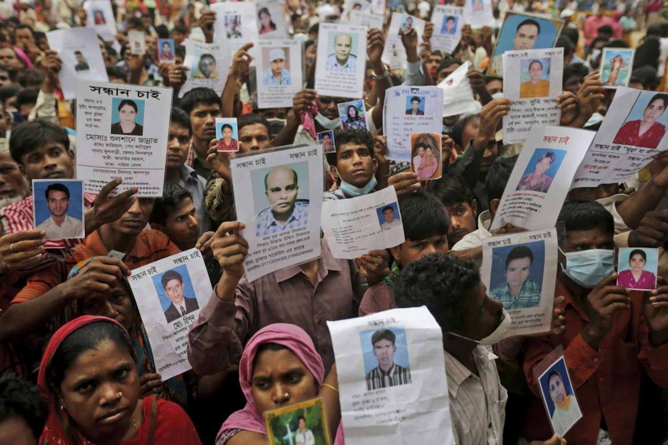 Bangladeshi relatives of missing workers in a building that collapsed Wednesday hold pictures of their family members in Savar, near Dhaka, Bangladesh, Sunday, April 28, 2013. Bangladesh rescuers on Sunday located nine people alive inside the rubble of the multi-story building, as authorities announced they will now use heavy equipment to drill a central hole from the top to look for survivors and dead bodies.