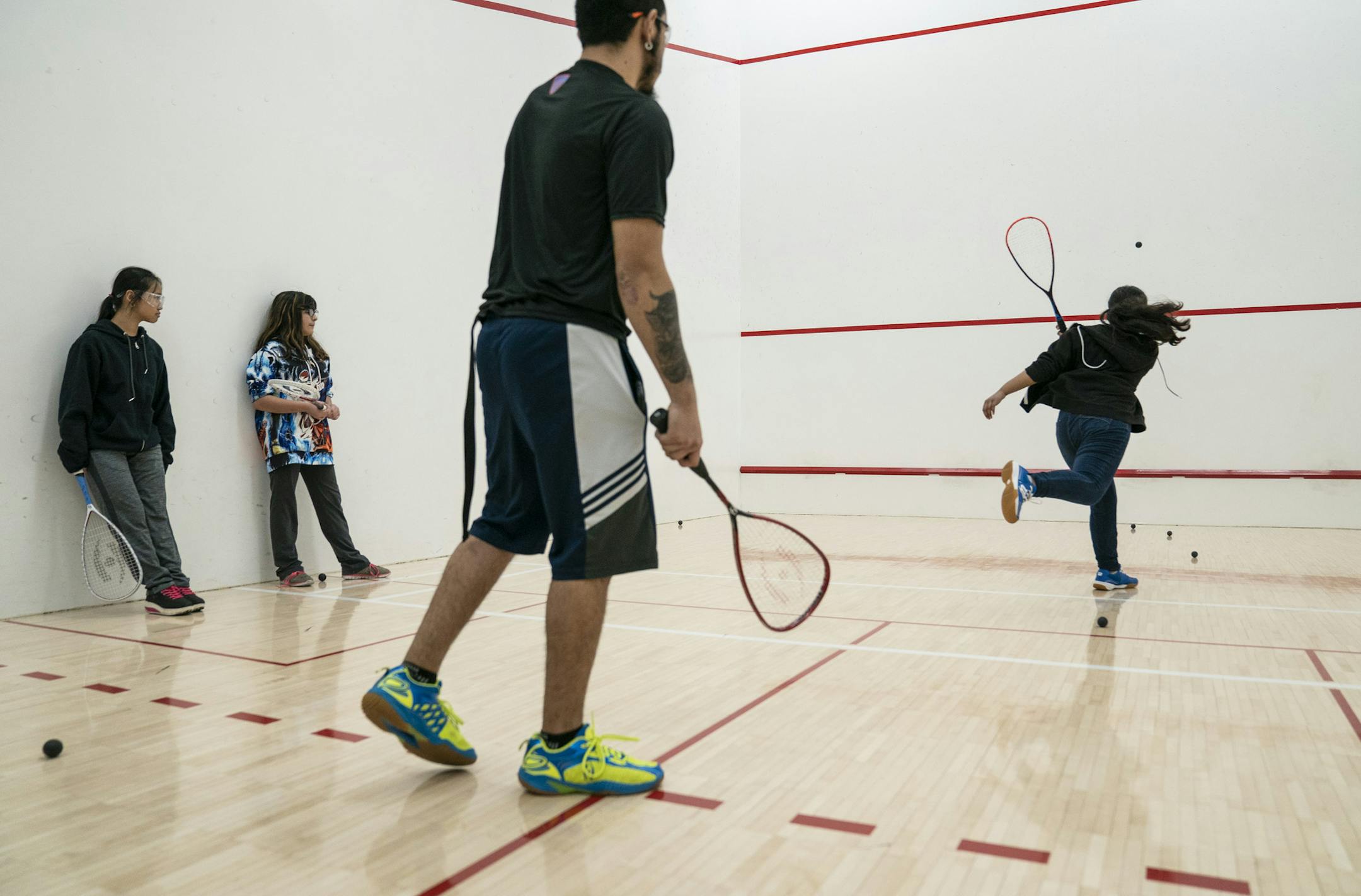 Coach and alum go the Beyond Walls program Jesus Viveros, center, coached students (from the left) Mya Nay Paw, 12, Vanessa Diaz,13, and Alina Hong,12, during a Beyond Walls Urban Squash Twin Cities practice at the University of Minnesota in Minneapolis, Minn., on Wednesday, January 23, 2019. ] RENEE JONES SCHNEIDER ¥ renee.jones@startribune.com