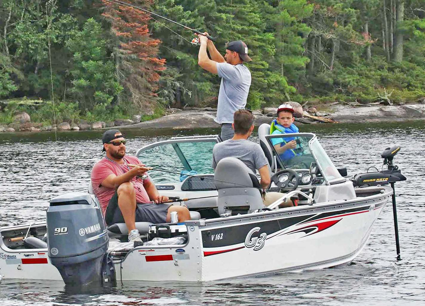 Mike Ward, standing, sets the hook on a walleye in Miles Bay on the Canadian side of Lake of the Woods. With him from left are Chris Ward, Steven Ward and Jack Kennedy