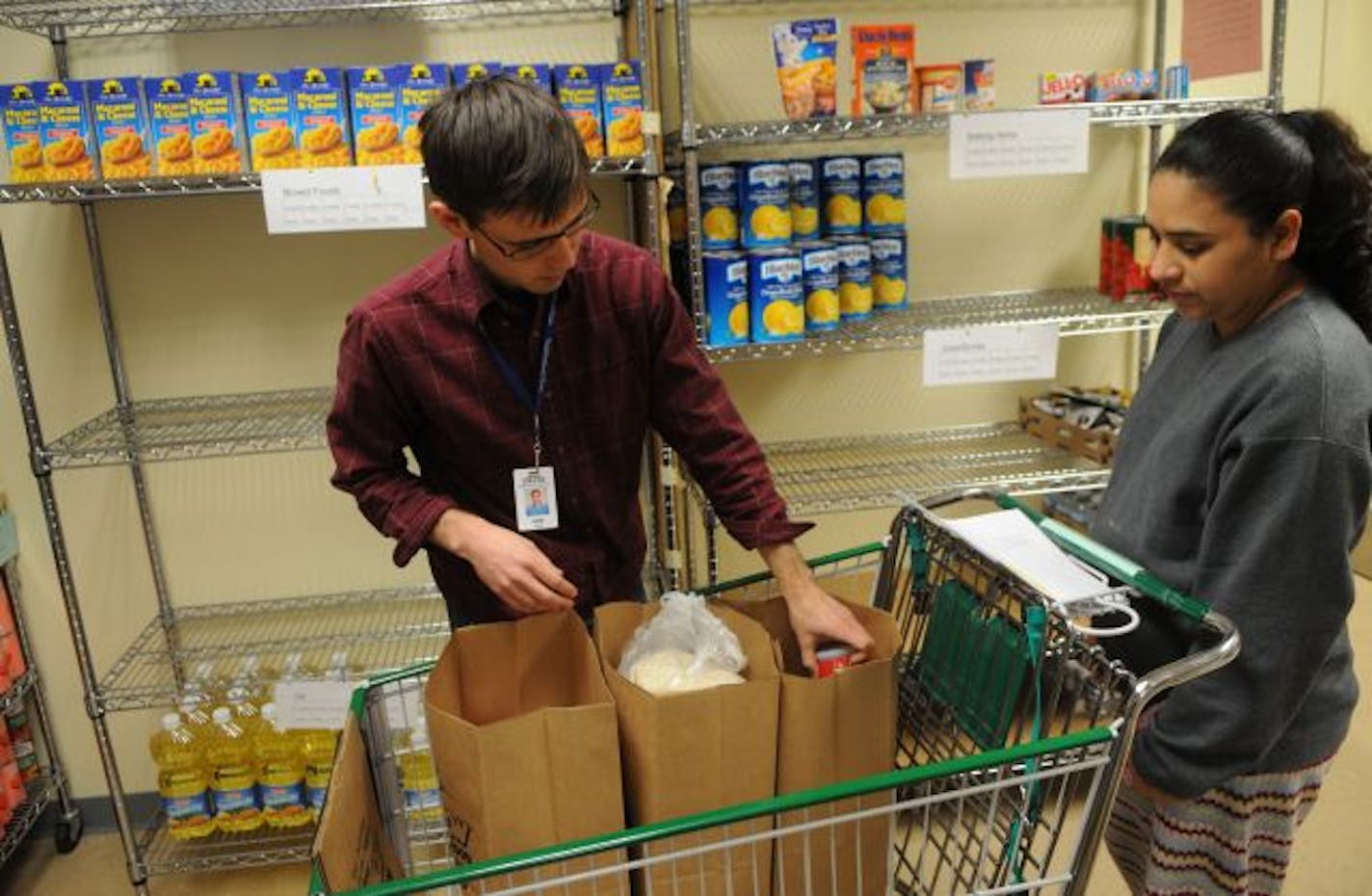 At the Neighborhood House in St. Paul on Monday, Sam Estes helped Francisca Quinones fill an order for her family of seven. With the demand for food growing, local food shelves are finding it difficult to stay well-stocked. And still, many low-income people don't take advantage of food shelves.