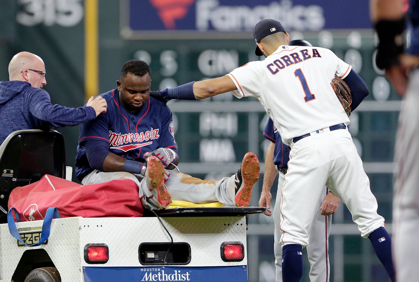 Twins designated hitter Miguel Sano gets a pat on the back from Houston Astros shortstop Carlos Correa as he is taken off the field after an injury on a play at second base