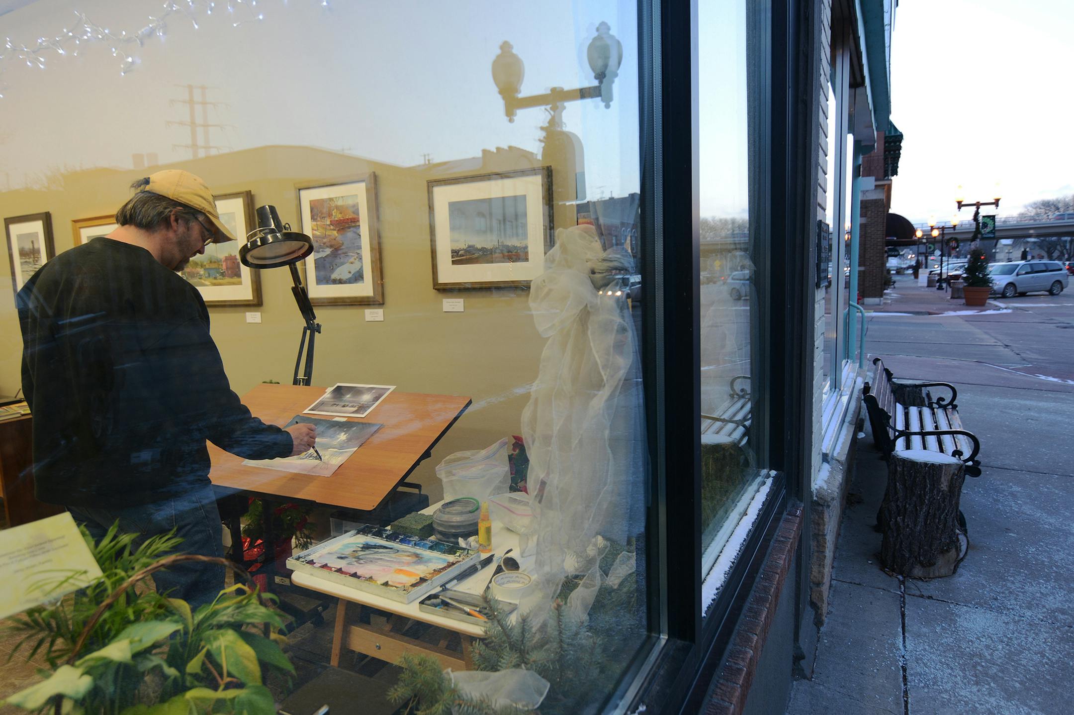 Andy Evansen painted by the window in his new gallery on Second Street in Hastings. Photo by Liz Rolfsmeier, Special to the Star Tribun e