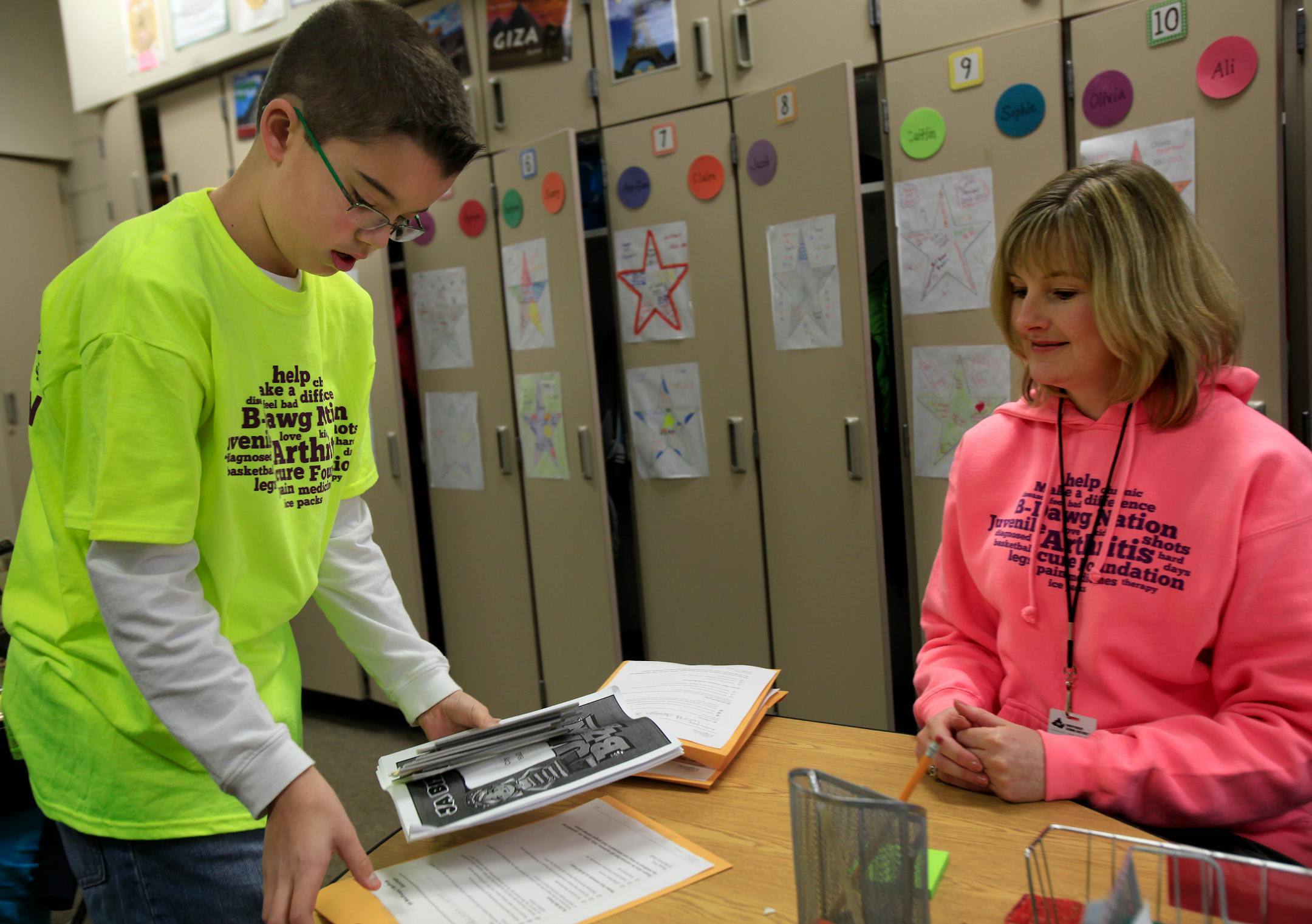 Jarrett Michie, 10, 5th grade student at Diamond Path School turns in his homework to his teacher Kathy Alderman in Apple Valley, MN on January 23, 2013.