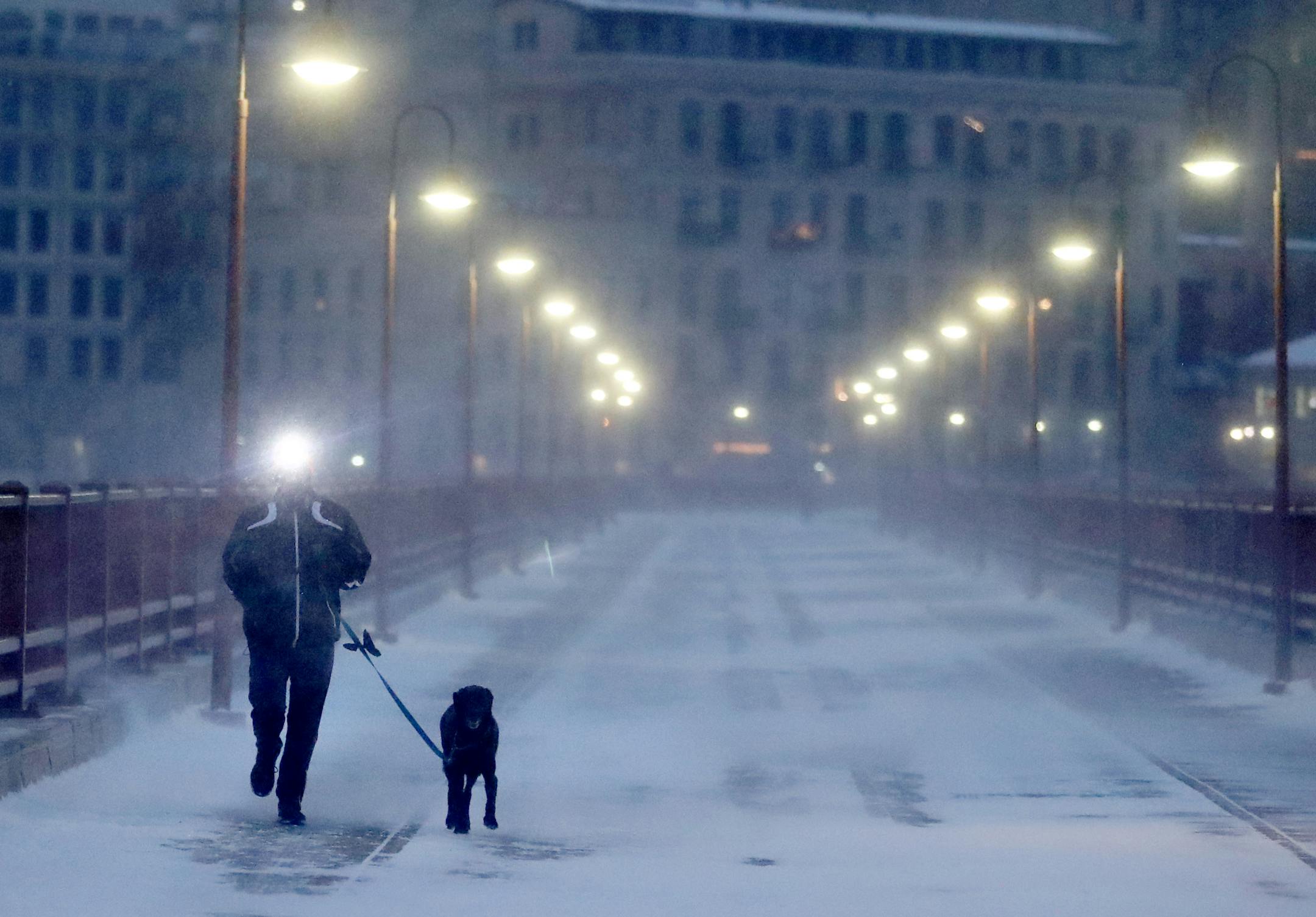 A runner and his dog brave frigid conditions while making their way east across the Stone Arch Bridge Thursday, Jan. 24, 2019, in Minneapolis. DAVID JOLES • david.joles@startribune.com Blast of Arctic air