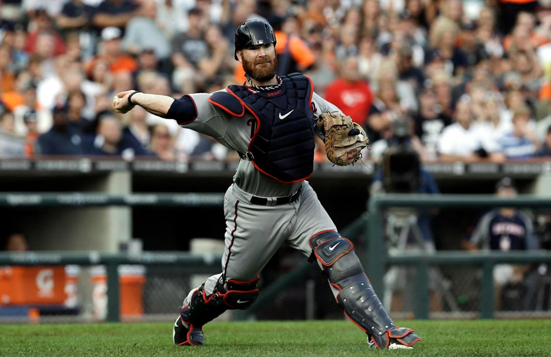 Minnesota Twins catcher Ryan Doumit throws to first base for the out on a bunt by Detroit Tigers' Andy Dirks in the second inning of a baseball game in Detroit, Tuesday, Aug. 20, 2013.