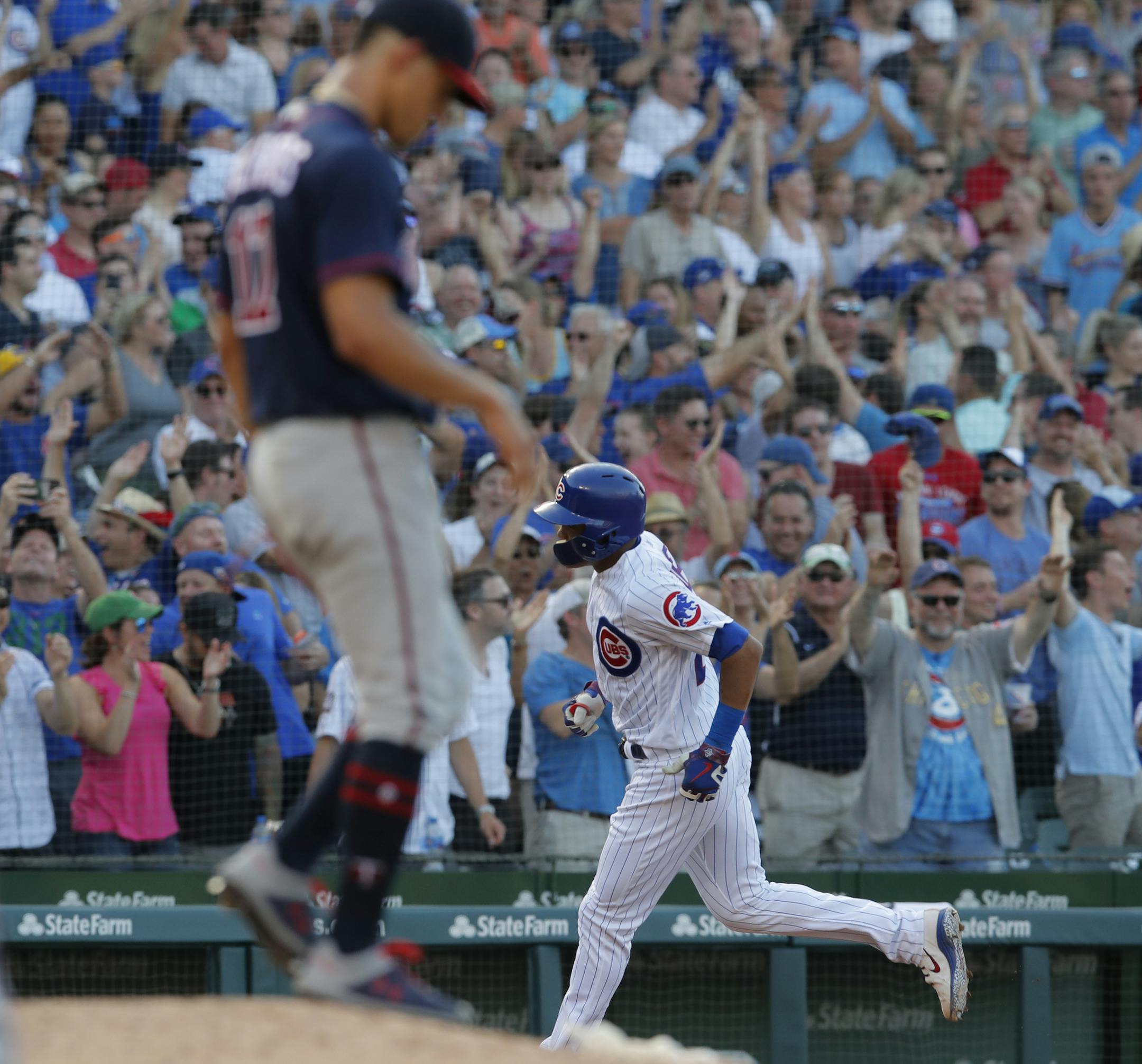 Chicago Cubs' Addison Russell, right, rounds the bases past Minnesota Twins' Jose Berrios after hitting a grand slam during the fifth inning of a baseball game Friday, June 29, 2018, in Chicago. (AP Photo/Jim Young)