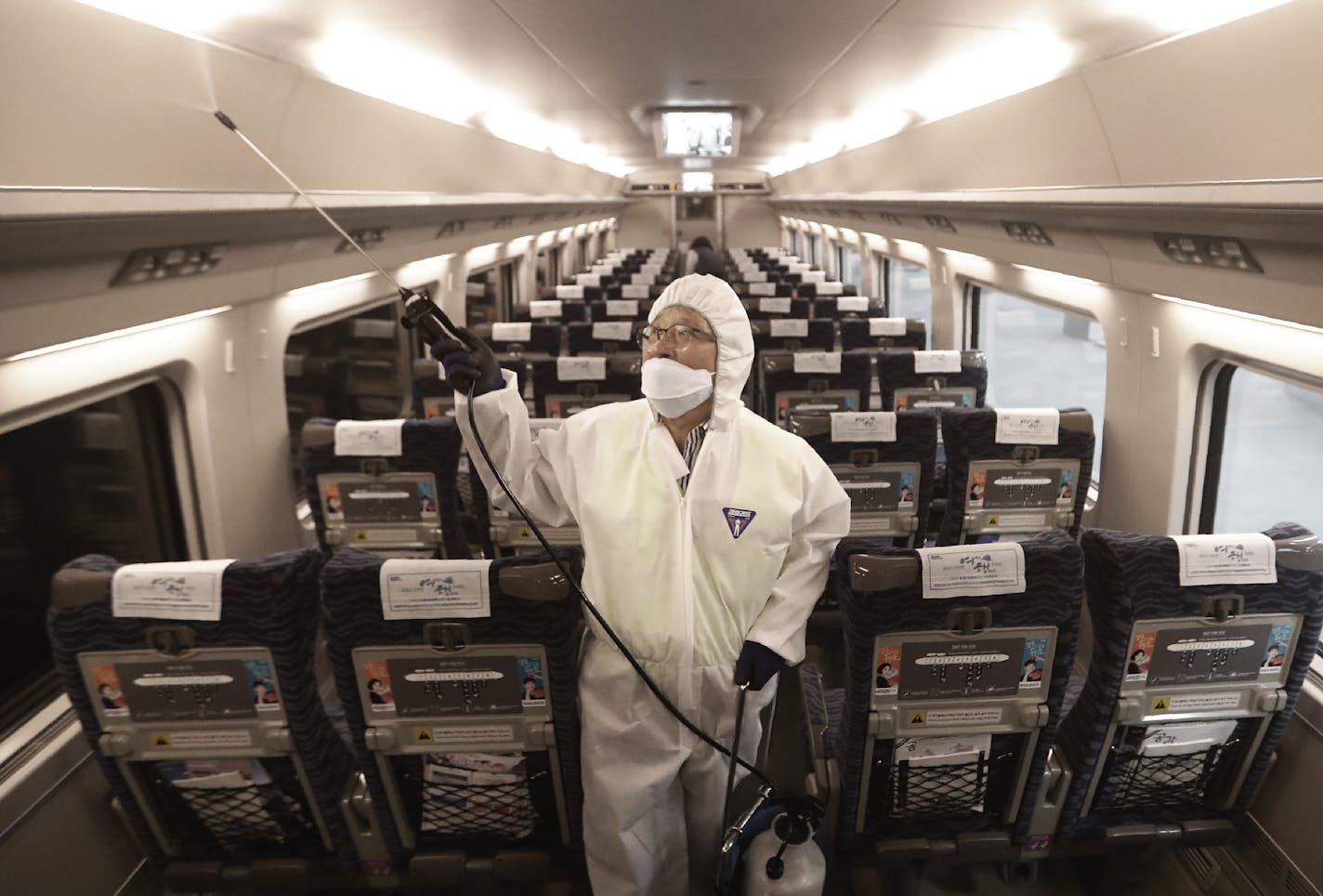 An employee sprayed disinfectant on a train in Seoul. In China, efforts to contain the new virus included lockdowns.