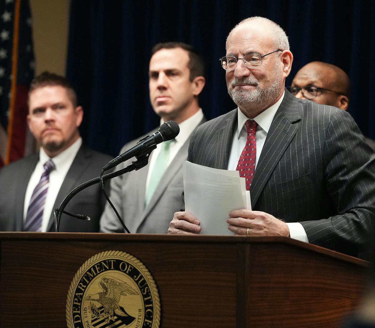 U.S. Attorney Andrew Luger, at podium, announced charges in March 2023 against 10 more people in the ongoing $250 million federal food aid fraud case involving the nonprofit Feeding Our Future.