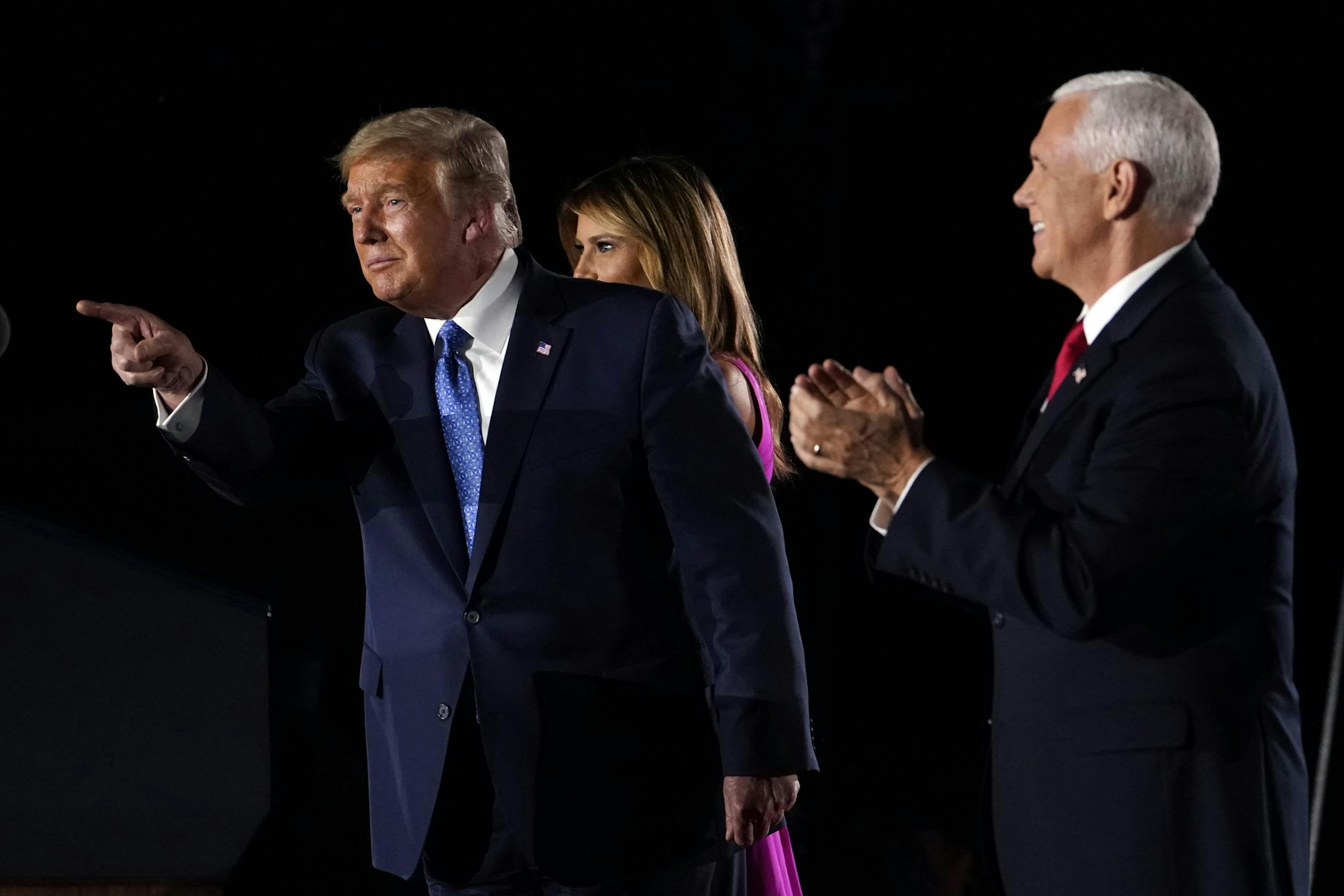 President Donald Trump points to supporters on stage with Vice President Mike Pence and first Lady Melania Trump on the third day of the Republican National Convention at Fort McHenry National Monument and Historic Shrine in Baltimore, Wednesday, Aug. 26, 2020. (AP Photo/Andrew Harnik)