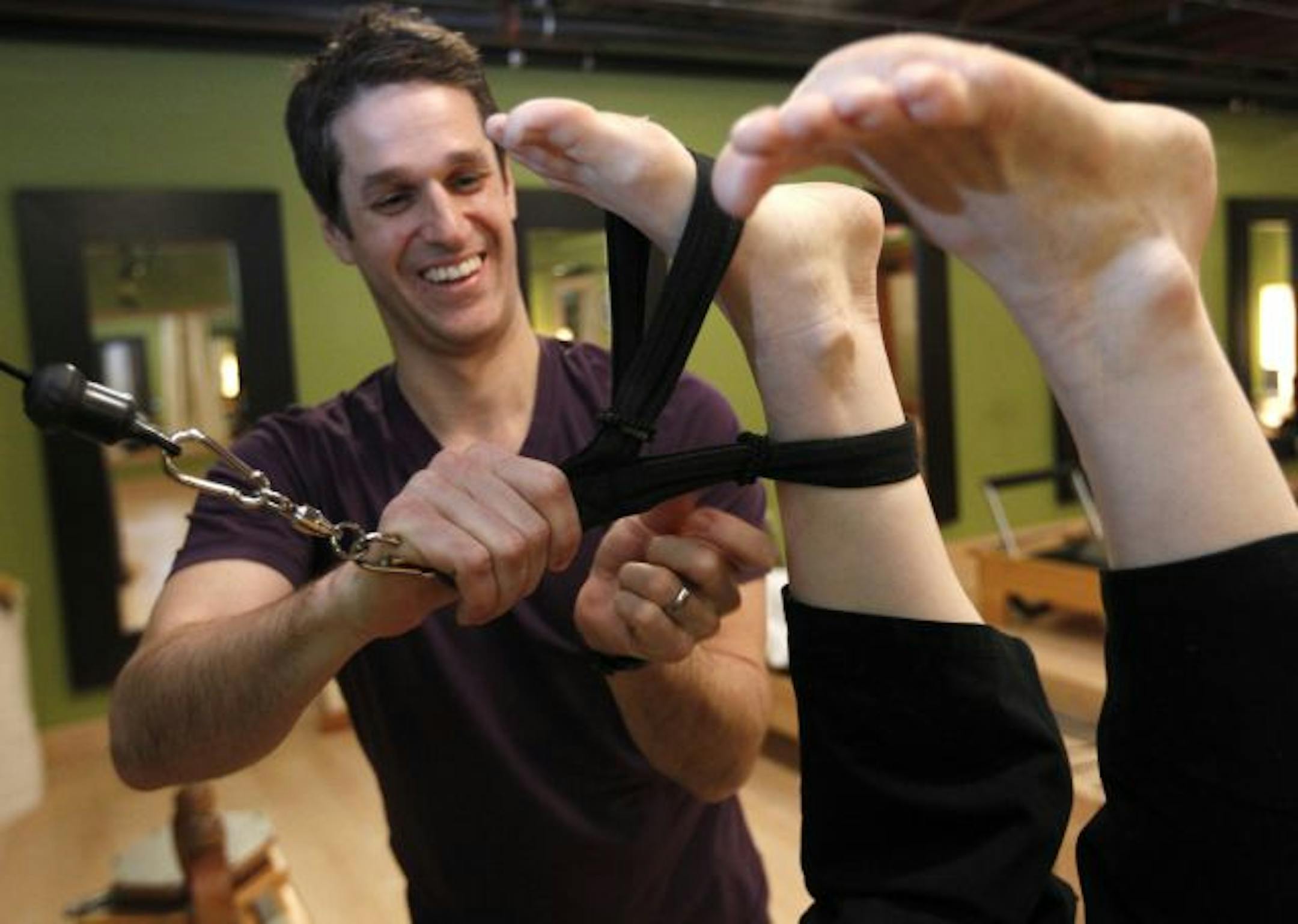Christian Twigg works with Natalie Brown on the Gyrotronics equipment at �The Awaken Pilates studio in the Lyn-lake neighborhood.