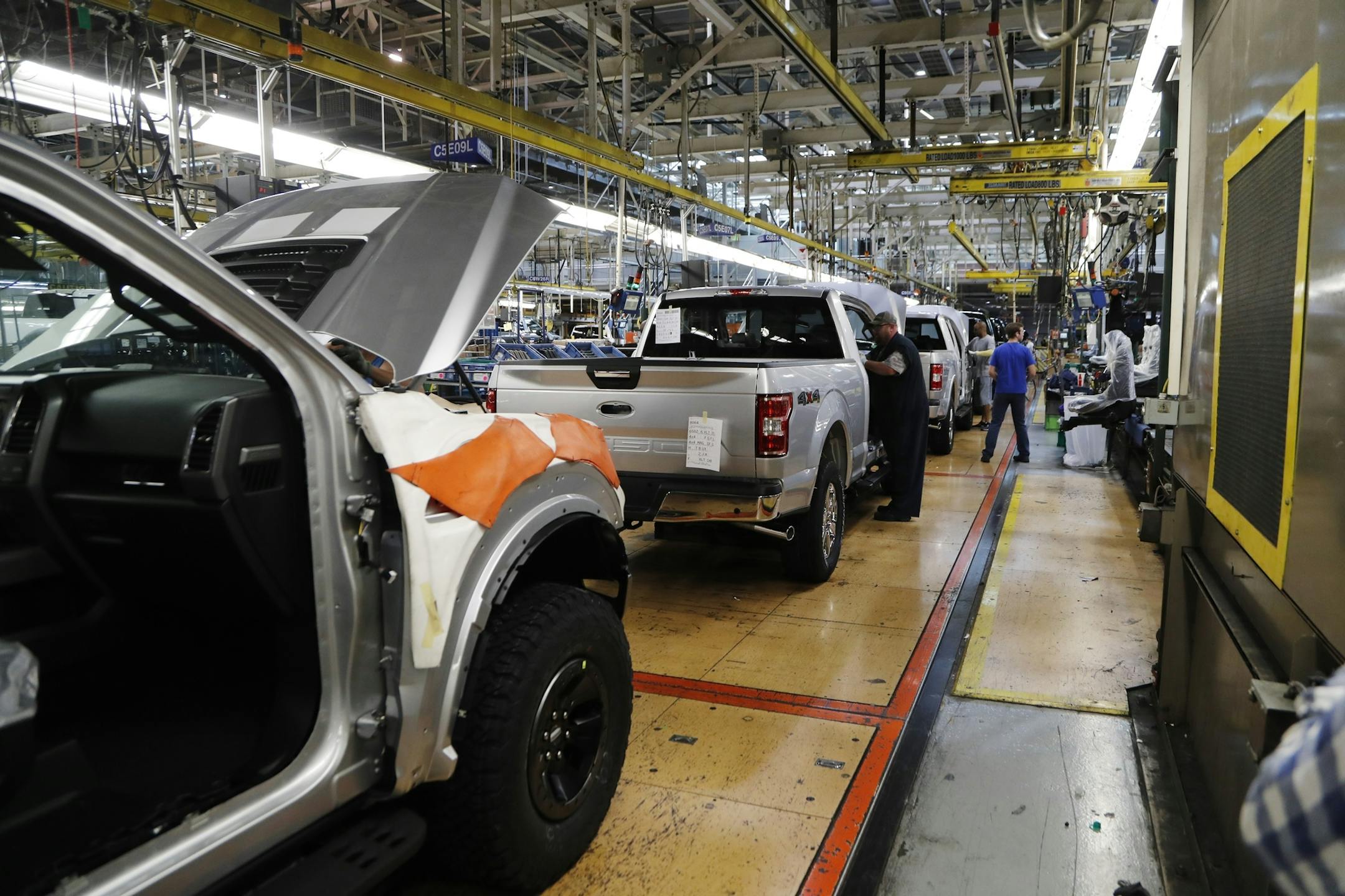FILE - In this Sept. 27, 2018, file photo a United Auto Workers assemblyman works on a 2018 Ford F-150 truck being assembled at the Ford Rouge assembly plant in Dearborn, Mich. Ford is recalling its popular F-150 pickup truck in Canada to fix a problem with electric tailgate latches, but identical trucks aren't being recalled in the U.S. (AP Photo/Carlos Osorio, File)