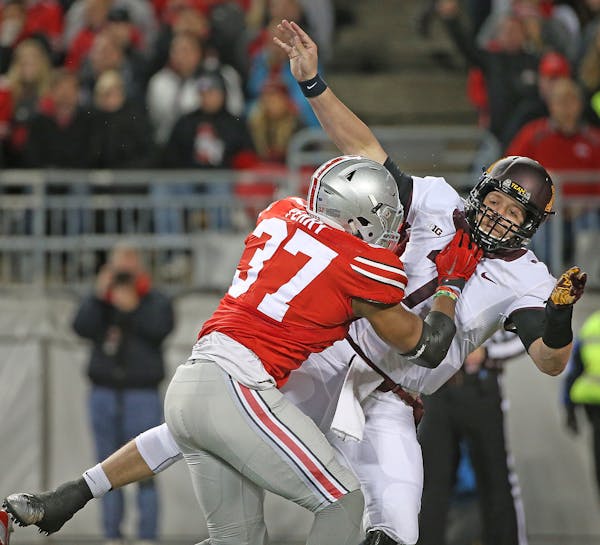Ohio State's linebacker Joshua Perry tackled Minnesota's quarterback Mitch Leidner just as he threw an interception for an Ohio touchdown in the secon