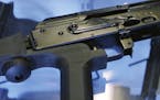 FILE - In this Oct. 4, 2017 file photo, a little-known device called a "bump stock" is attached to a semi-automatic rifle at the Gun Vault store and s