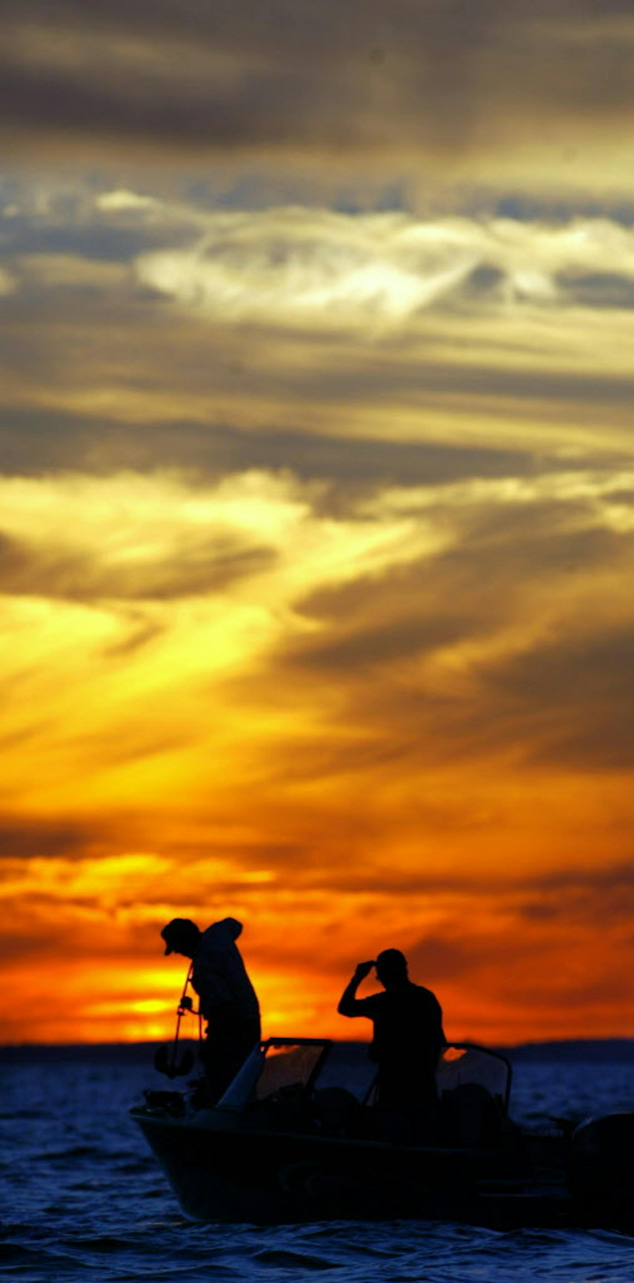 7/23/03- Members of the Minnesota Depaprtment of Natural Resources pull in the anchor as they prepare to move to a new spot while fishing for walleye on the southeastern part of Lake Mille Lacs. The DNR has been catching the fish and releasing them into nets for several days as part of the Hooking Mortality tests they are condcuting this year on the lake. By hooking and releasing the Walleye, they can learn how many fish that anglers release actually survive when thrown back. MNHISTLAKES ORG XMI