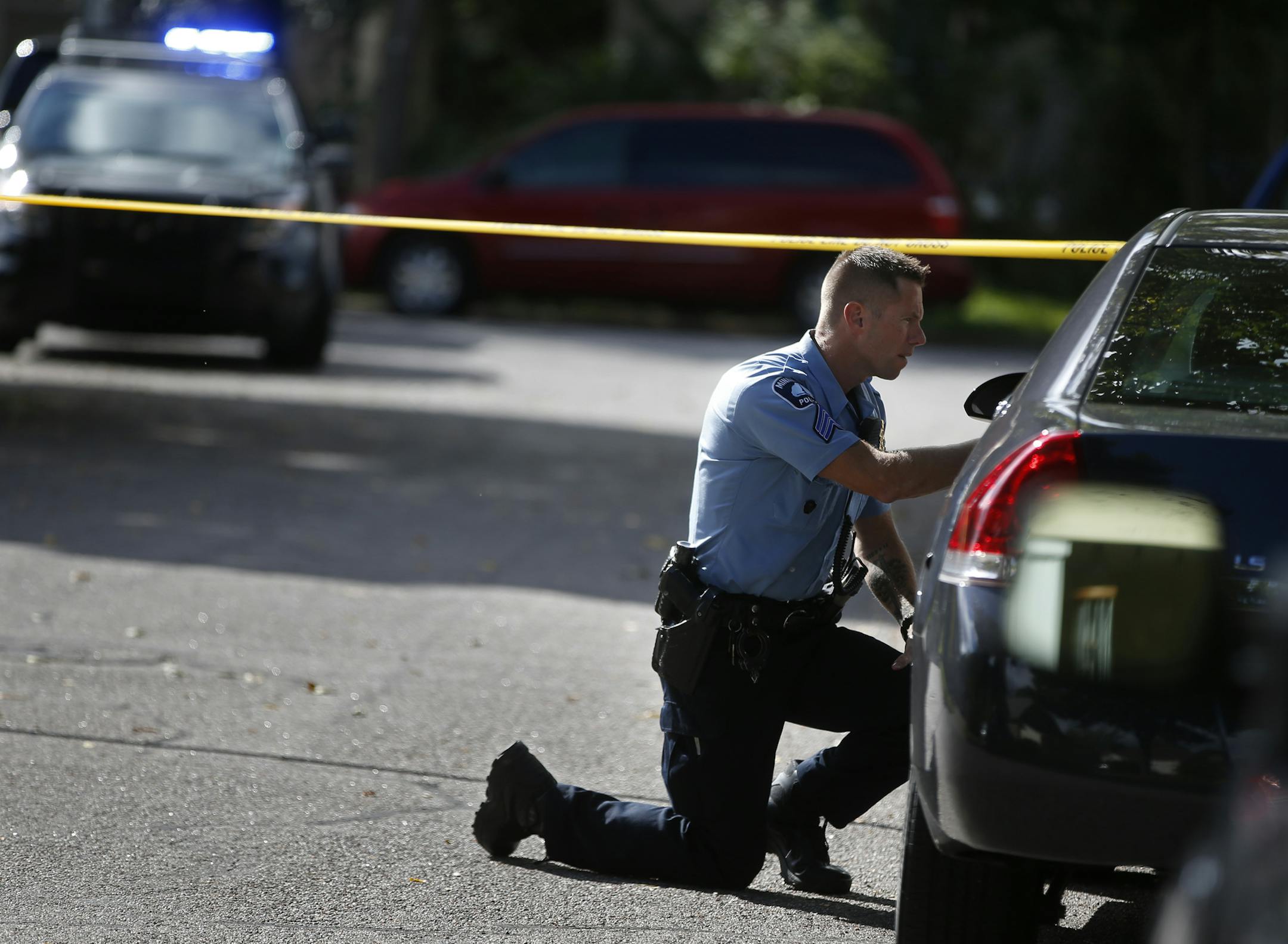 Two blocks west of Edison H.S. in Minneapolis on September 21, 2014, police officers examined the crime scene where a homocide occurred.]Richard Tsong-Taatarii/rtsong- taatarii@startribune.com