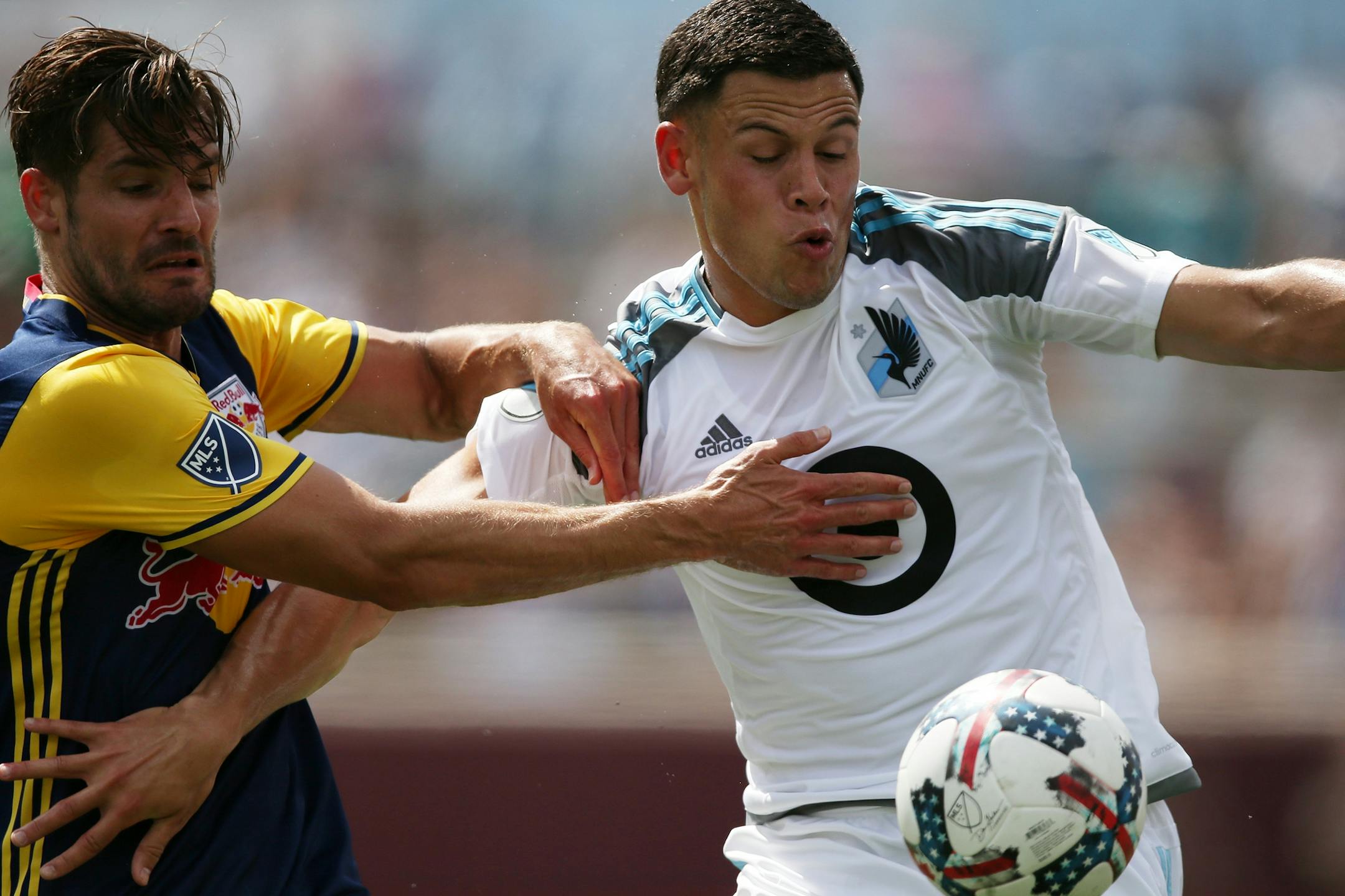 Minnesota United forward Christian Ramirez (21) struggled against New York Red Bulls defender Damien Perrinelle (55) as he raced for the New York Red Bulls goal in the first half.