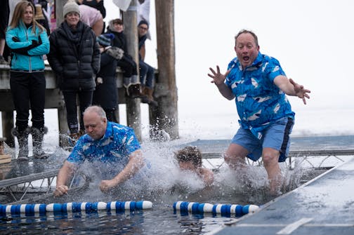 From the left; Steve Bolz, George Crawford and Rob Andres jump together into the freezing cold waters of Lake Minnetonka.