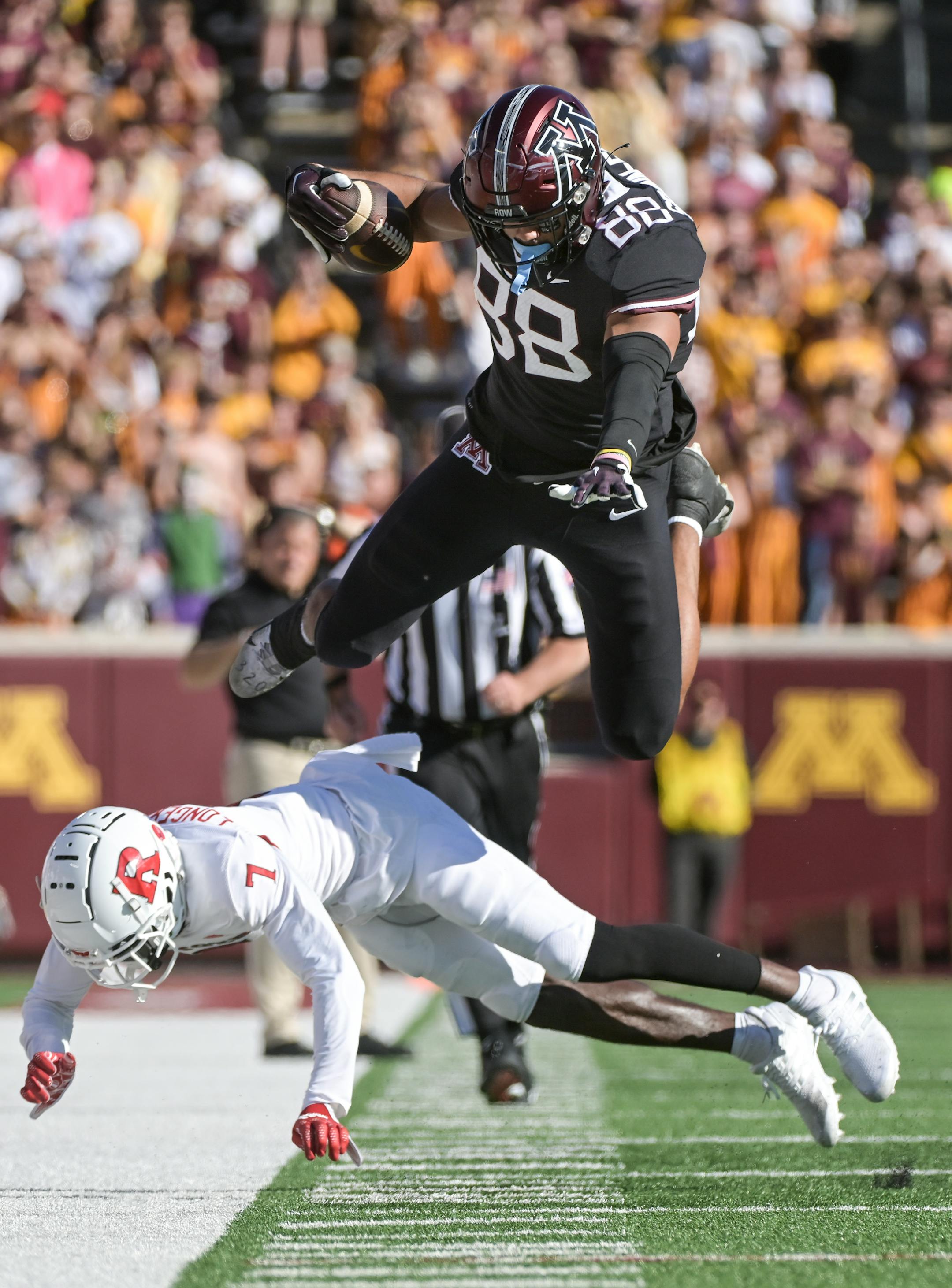 Minnesota Golden Gophers tight end Brevyn Spann-Ford (88) leaps over Rutgers Scarlet Knights defensive back Robert Longerbeam (7) as he's pushed out of bounds.