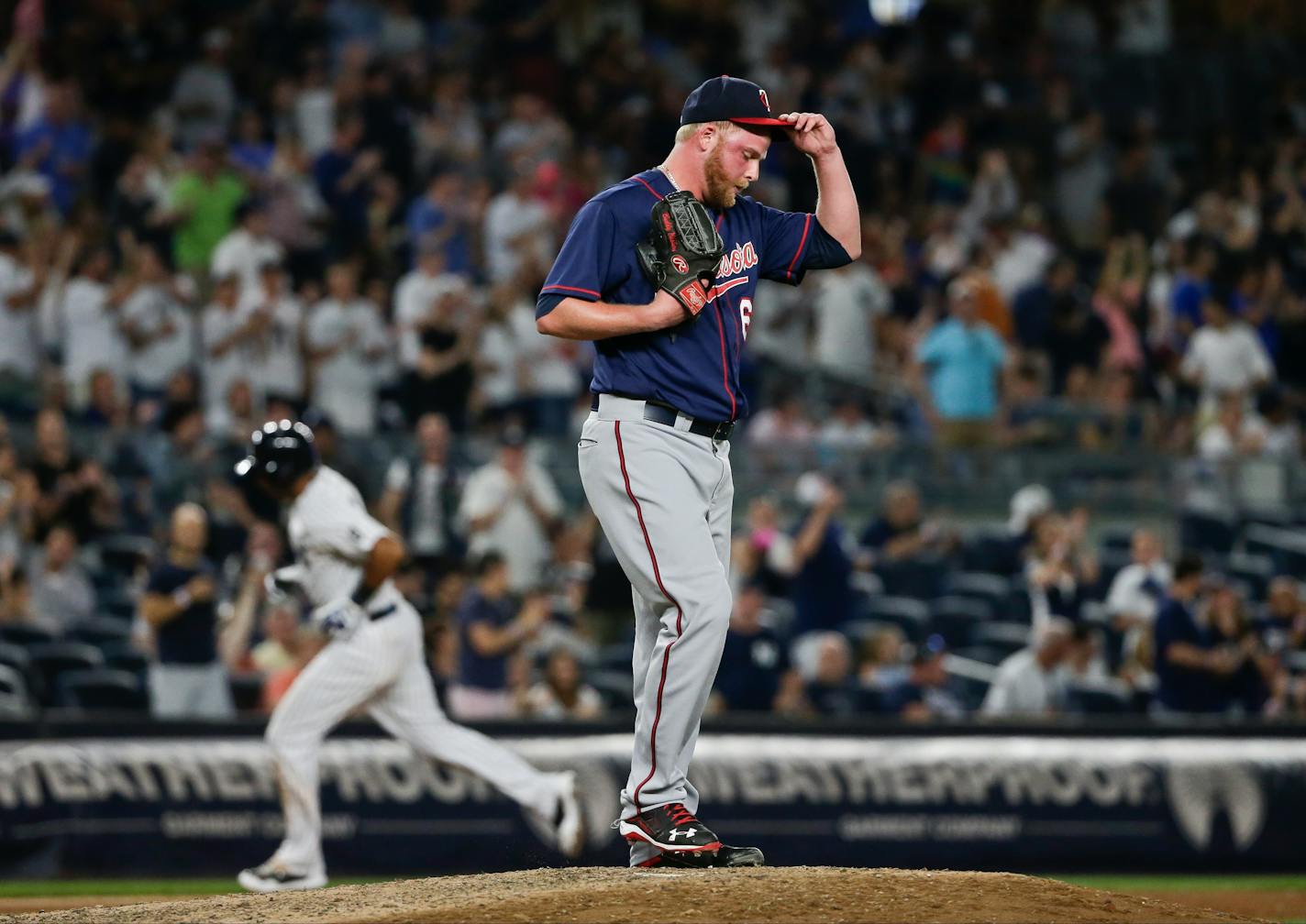 Twins relief pitcher Buddy Boshers adjusted his cap as the Yankees' Aaron Hicks ran the bases after hitting a home run during the eighth inning Friday night in New York.