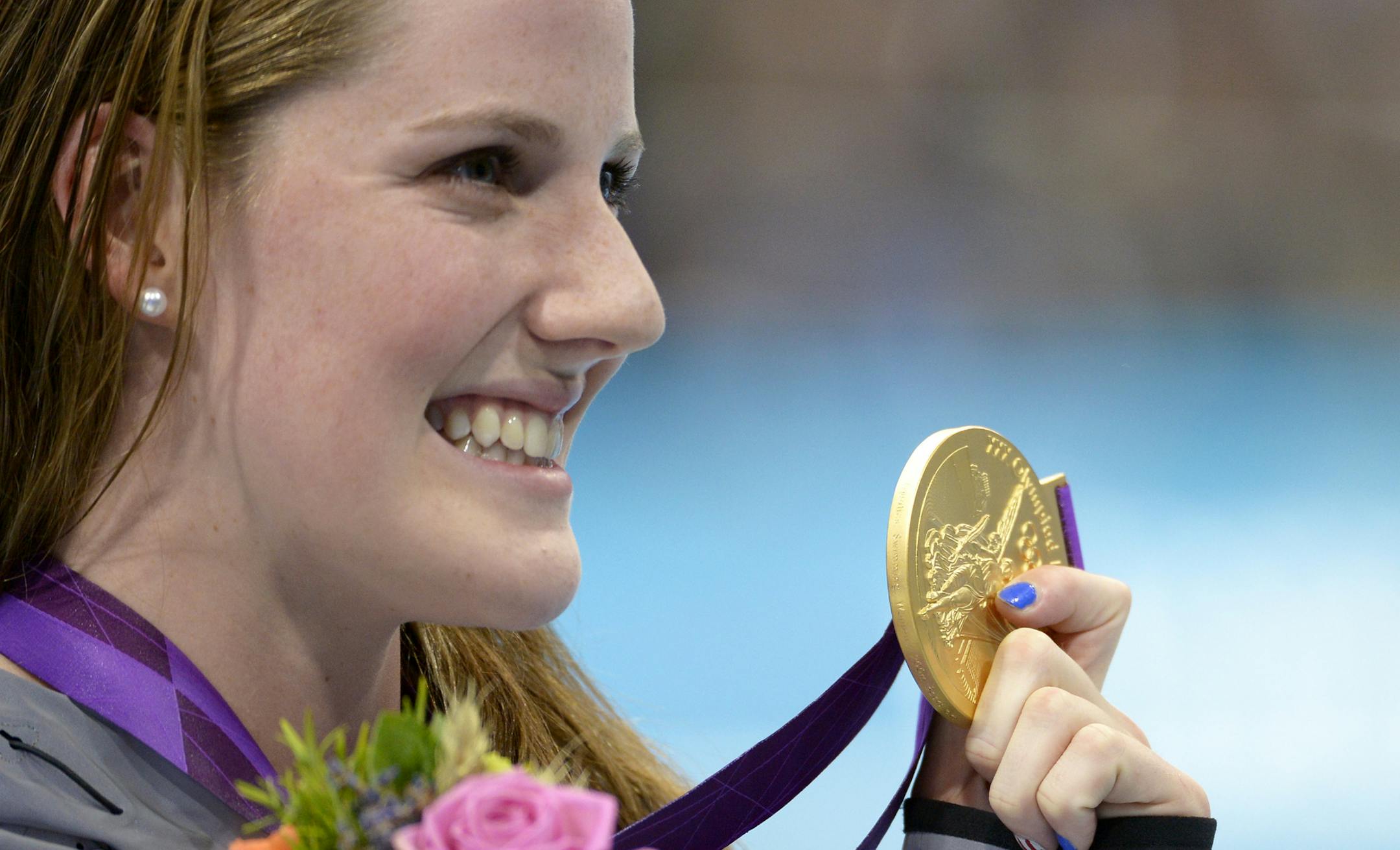 United States' Missy Franklin poses with her gold medal in the women's 200-meter backstroke final during the men's 50-meter freestyle final at the Aquatics Centre in the Olympic Park during the 2012 Summer Olympics in London, Friday, Aug. 3, 2012. (AP Photo/Mark J. Terrill) ORG XMIT: OSWM412