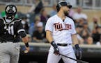 Minnesota Twins' Trevor Plouffe, right, reacts after striking out as Chicago White Sox catcher Alex Avila, left, heads to the dugout during the first 