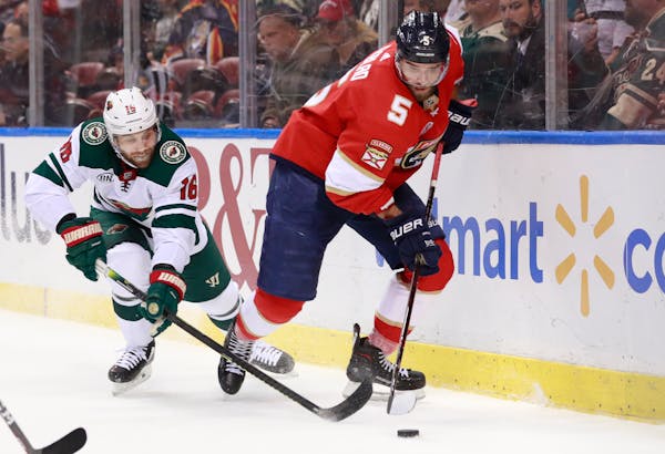 Minnesota Wild left wing Jason Zucker (16) and Florida Panthers defenseman Aaron Ekblad (5) battle for the puck during the first period of an NHL hock