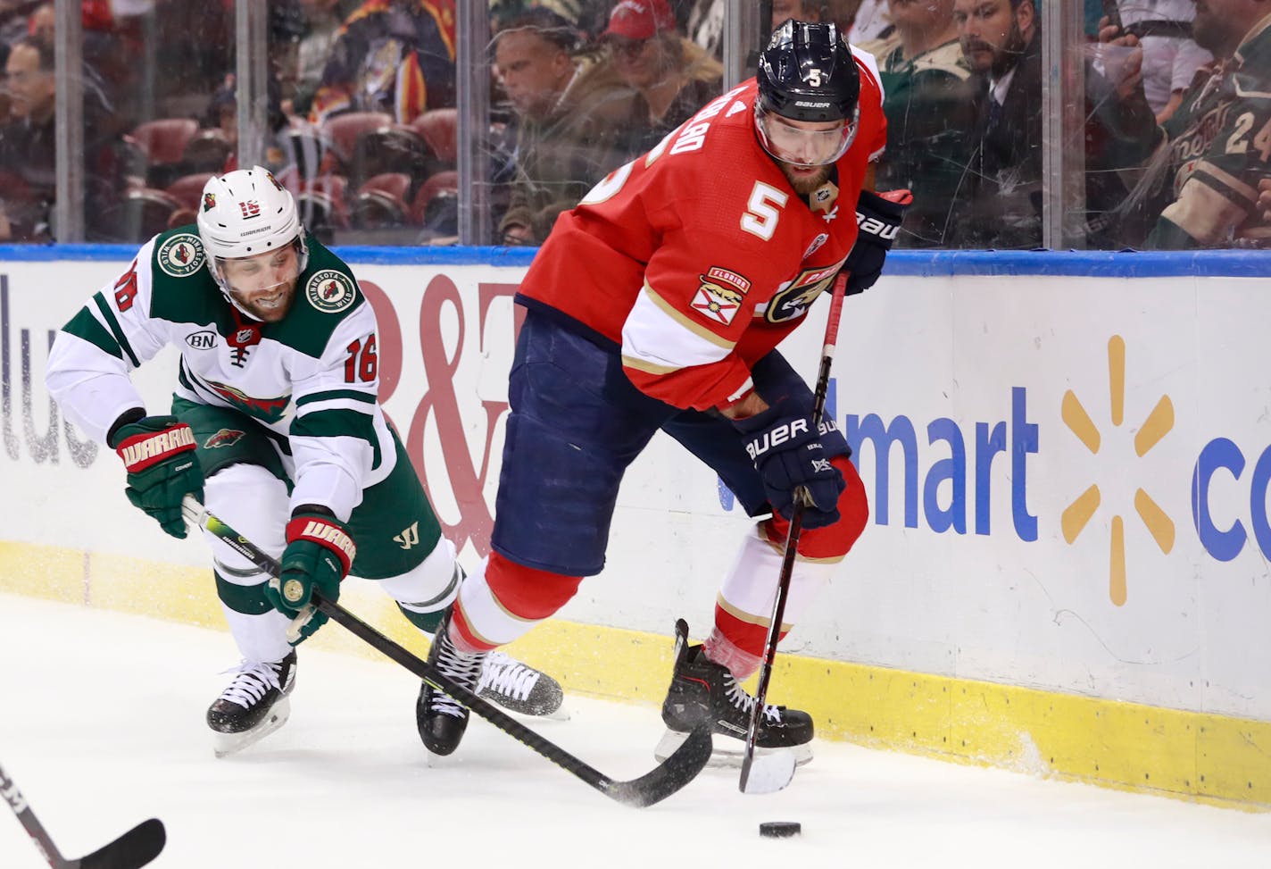 Minnesota Wild left wing Jason Zucker (16) and Florida Panthers defenseman Aaron Ekblad (5) battle for the puck during the first period of an NHL hockey game, Friday, March 8, 2019, in Sunrise, Fla. (AP Photo/Wilfredo Lee)