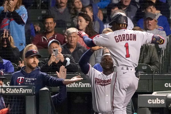 Minnesota Twins' Nick Gordon (1) celebrates his two-run home run off Chicago Cubs starting pitcher Alec Mills, with manager Rocco Baldelli, left, and 