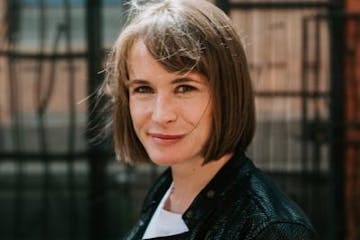 photo of author Abigail Dean in front of  an iron fence