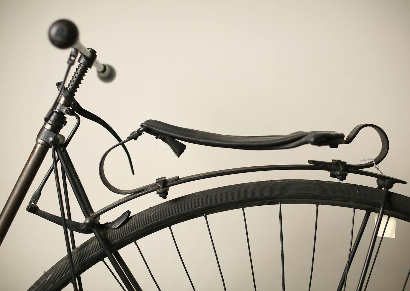 Detail of the handlebars, brake and saddle of an American Star bicycle dating to 1884. The Star&#x2019;s pedals ratcheted up and down around a flywheel.