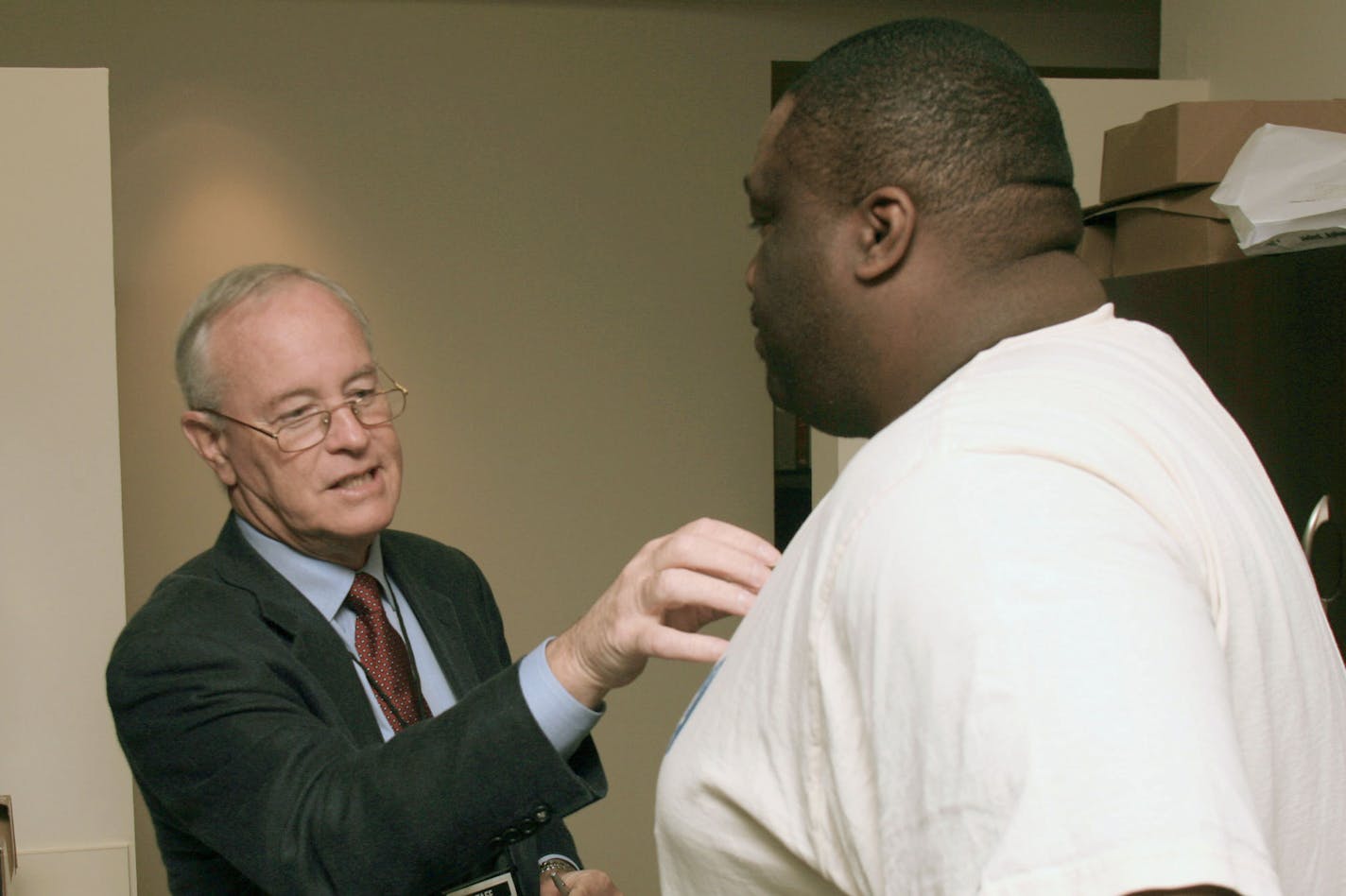 Dr. Archie Roberts, left, talks to former Miami Dolphins football player Keith Sims at the Living Heart NFL Players CV Health Program, Wednesday, Jan. 31, 2007, in Miami. About 60 former players were expected to take part of the medical screenings sponsored by the Living Heart Foundation, a Little Silver, N.J.-based organization that is studying health risks facing professional football players. (AP Photo/Luis M. Alvarez) ORG XMIT: FLLA103