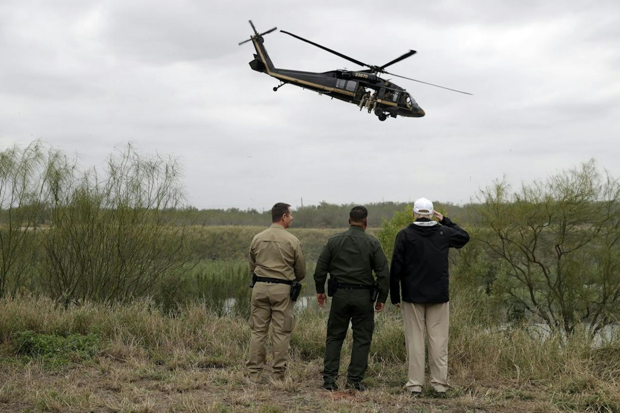 President Donald Trump salutes as a U.S. customs and Border Protection helicopter passes as he tours the U.S. border with Mexico at the Rio Grande on the southern border, Thursday, Jan. 10, 2019, in McAllen, Texas.