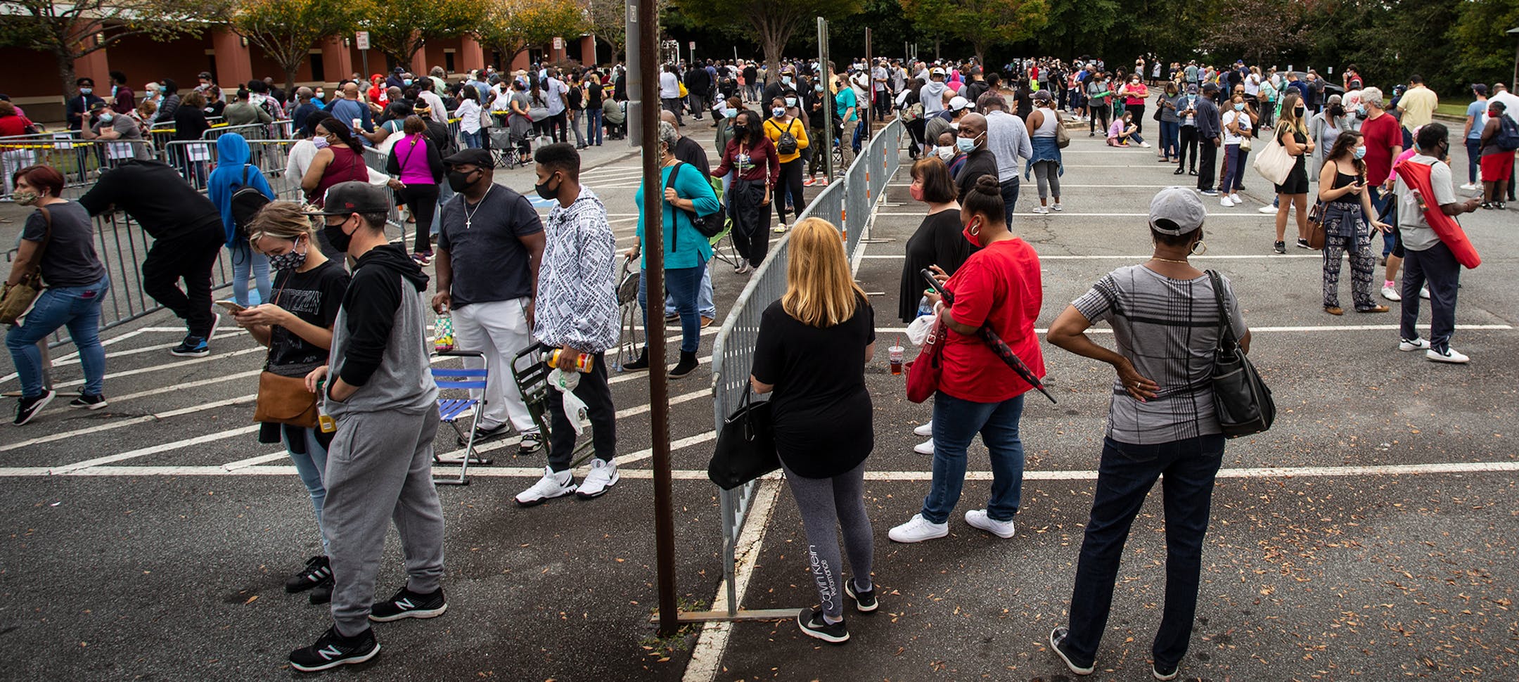 FILE - In this Oct. 12, 2020, file photo, hundreds of people wait in line for early voting in Marietta, Ga. Black people are going to the polls by the thousands and waiting in lines for hours to vote early in Georgia. Black people are going to the polls by the thousands and waiting in lines for hours to vote early in Georgia. (AP Photo/Ron Harris, File)