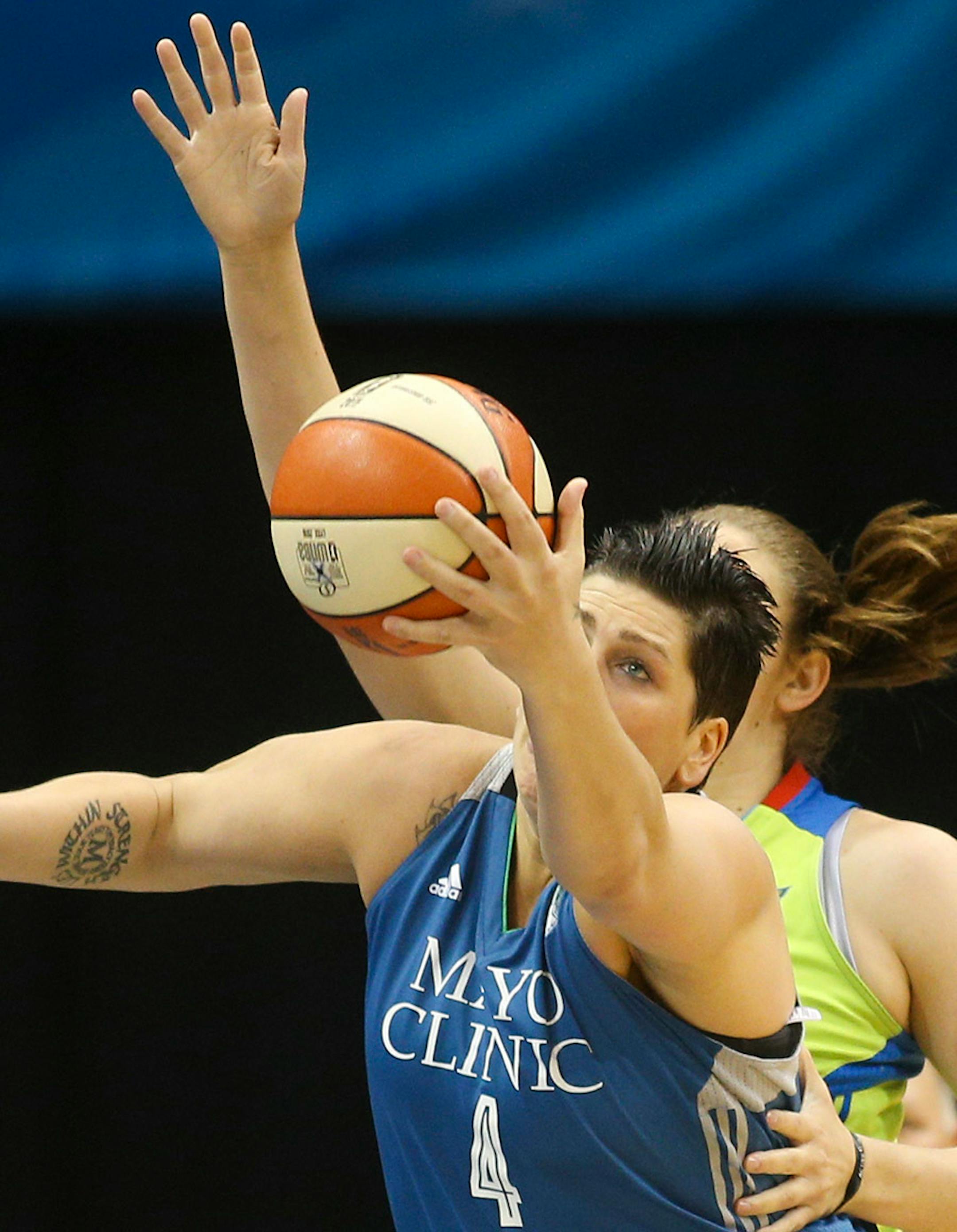 Minnesota Lynx center Janel McCarville (4) brings down a rebound over Dallas Wings center Courtney Paris (3).