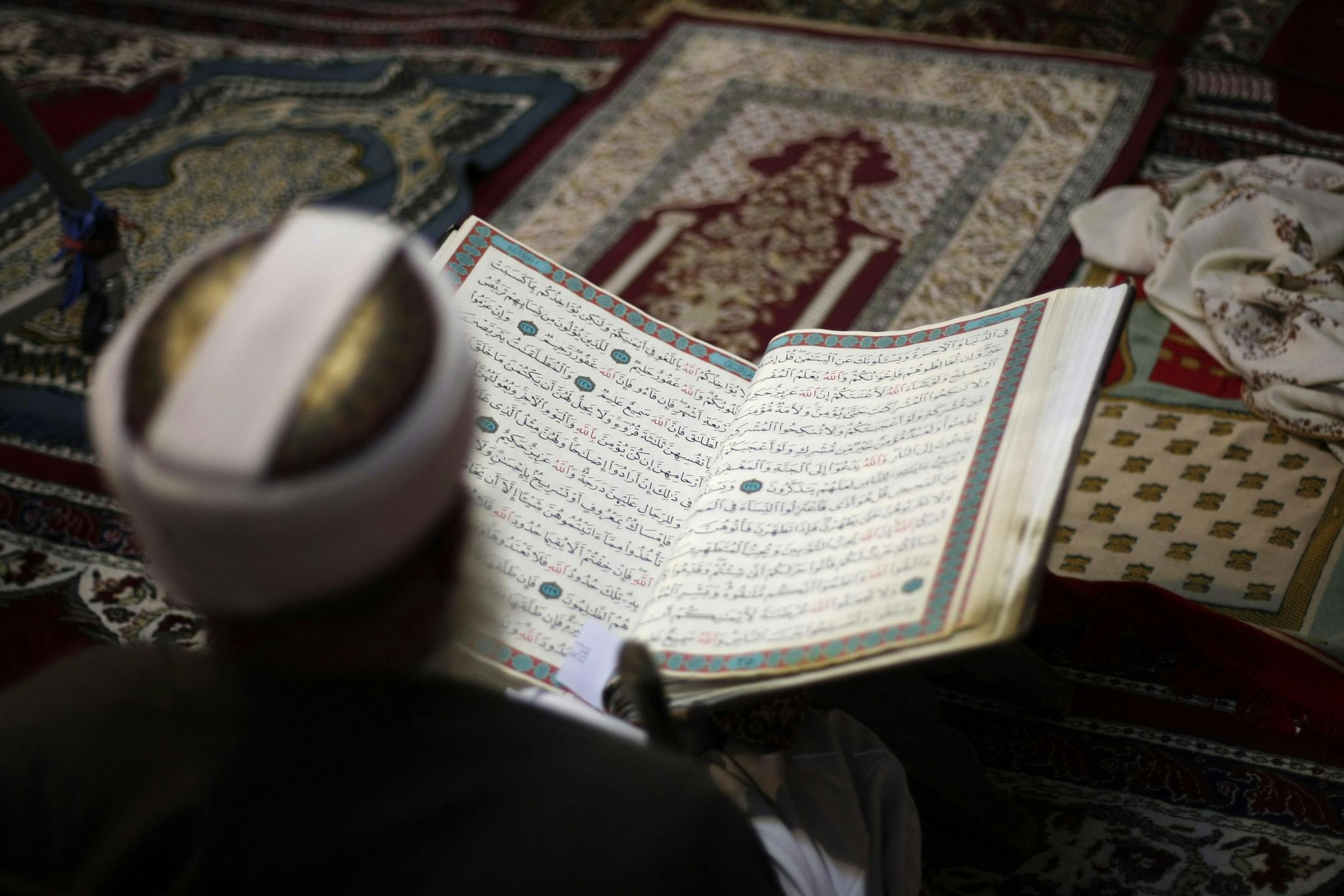 An elderly man reads verses of the Quran, Islam's holy book, on the first day of the fasting month of Ramadan in the grand Mosque in the old city of Sanaa, Yemen, Wednesday, July 10, 2013. Muslims began observing the dawn-to-dusk fast for the month of Ramadan across the Middle East on Wednesday, even as the region is shaken by the crisis in Egypt and the U.N. food agency warned that Syria's civil war has left 7 million people in need of food aid.